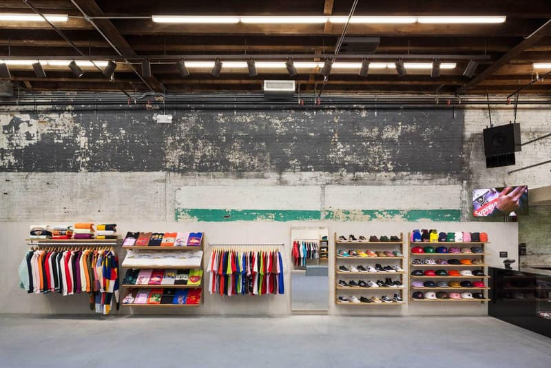 Supreme のブルックリン店の内装デザインを隅々まで撮影したフォトセットが到着 『Supreme Brooklyn』の前は配送用トラックの収納スペースだったとのこと 〈Supreme(シュプリーム)〉は昨年10月、ニューヨーク・ブルックリン地区に新ストアをオープン。実はこの場所、ストリートウェアの雄のためにNeil Logan(ニール・ローガン)とMinji Kim(ミンジ・キム)の2人が改装する前は、2,938㎡を要する配送用トラックの収納スペースだったのだ。 天井が高く、しっくりを剥がした2m超えのブロック壁に囲まれた空間は、隆起したグラインドレール付きのメタルベンチを設置することで、質素ながらもどこかインダストリアルな雰囲気が漂う。また、店内の奥には『Supreme Brooklyn』の最大の特徴である木製のスケートボウルが鎮座。『ArchDaily』はこのアイコンについて、「バルト海産の樺の木でできたベニヤ板を100%使用したこのボウルは、アートコレクティブのSimparchがシカゴで製造して、ここまで運び、インストールしたものです」と説明している。 また、このジオメトリックなボウルの裏には、カーテンで覆われた更衣室が2部屋隠れており、スケートクリップを流している店頭の液晶も背面には鏡を設置。そして、入り口の壁裏を覆い尽くすスケートデッキとアートワークも見逃せないポイントだろう。 『Supreme Brooklyn』の内装を隅々まで撮影したフォトセットは、上のフォトギャラリーからどうぞ。 ちなみに、〈Sup〉が2018年春夏コレクション内の“Alphabet”シリーズの販売を突如中止した理由はご存知?