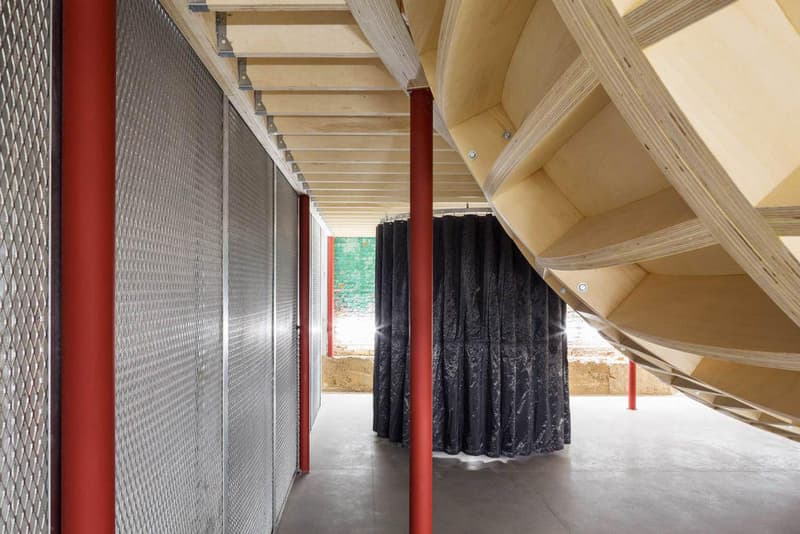 Supreme のブルックリン店の内装デザインを隅々まで撮影したフォトセットが到着 『Supreme Brooklyn』の前は配送用トラックの収納スペースだったとのこと 〈Supreme（シュプリーム）〉は昨年10月、ニューヨーク・ブルックリン地区に新ストアをオープン。実はこの場所、ストリートウェアの雄のためにNeil Logan（ニール・ローガン）とMinji Kim（ミンジ・キム）の2人が改装する前は、2,938㎡を要する配送用トラックの収納スペースだったのだ。  天井が高く、しっくりを剥がした2m超えのブロック壁に囲まれた空間は、隆起したグラインドレール付きのメタルベンチを設置することで、質素ながらもどこかインダストリアルな雰囲気が漂う。また、店内の奥には『Supreme Brooklyn』の最大の特徴である木製のスケートボウルが鎮座。『ArchDaily』はこのアイコンについて、「バルト海産の樺の木でできたベニヤ板を100%使用したこのボウルは、アートコレクティブのSimparchがシカゴで製造して、ここまで運び、インストールしたものです」と説明している。  また、このジオメトリックなボウルの裏には、カーテンで覆われた更衣室が2部屋隠れており、スケートクリップを流している店頭の液晶も背面には鏡を設置。そして、入り口の壁裏を覆い尽くすスケートデッキとアートワークも見逃せないポイントだろう。  『Supreme Brooklyn』の内装を隅々まで撮影したフォトセットは、上のフォトギャラリーからどうぞ。  ちなみに、〈Sup〉が2018年春夏コレクション内の“Alphabet”シリーズの販売を突如中止した理由はご存知？