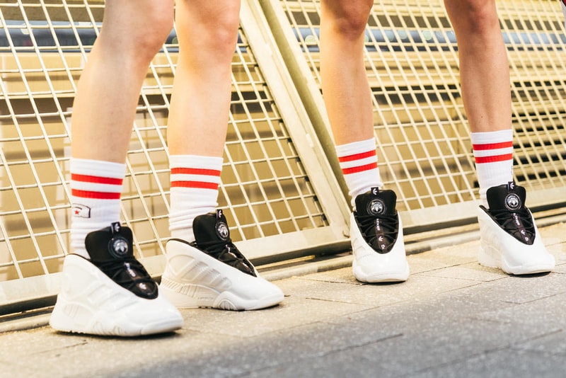 アメリカへの愛を表現した Alexander Wang の最新コレクションの舞台裏に潜入 『MTV』が一斉を風靡した2000年初頭を着想源に、ファッションの震源地であるアメリカが長い歴史で築き上げてきたスタイルの全てを凝縮 シンプルに“COLLECTION 1”というタイトルを掲げ、マンハッタンのハーバーサイド『Pier 19』で開催された〈Alexander Wang（アレキサンダー・ワン）〉の最新ランウェイは、Wangが想うアメリカンドリームと移民としてのルーツを表現したものだった。記録的大ヒットを記録したChildish Gambino（チャイルディッシュ・ガンビーノ）の“This is America”をクロージングソングに採用したショーは、Wangの「移民としてのルーツを持つアメリカ人のプライド」が来場に直に伝わったことだろう。だが、このコレクション自体は、何一つ混じり気のないアメリカ人らしさを称賛するものだったのである。  巨大な正方形の空間にそれと相反するヘヴィメタルのサウンドトラックが響きわたった今回のランウェイは、1980〜90年代の『MTV』や『Times Square』に訪れた観光客の服装など、現代アメリカファッションの原型を色濃く反映している。コレクションの根幹をなすクロップドパンツ、ローライダージーンズ、ケミカルなビブス、頭に巻かれたバンダナは、2000年の「MTV Video Music Awards」に登場したJennifer Lopez（ジェニファー・ロペス）がインスピレーションソース。また、〈adidas（アディダス）〉とのコラボレーションシューズはCrazy 97 EQT Elevationをベースのシルエットに採用しているほか、サングランスと米国への愛国心を感じさせるフェイスペイントも“COLLECTION 1”を象徴するものだった。その他にもオーバーサイズのジャージ、シルエットを誇張したレザージャケット、多様多種なレザーベルト、オンブレシャツ＆ショーツ、ペイズリープリントのボタンアップなど、コレクション全体をレッド/ブラックで統一した〈AW〉の最新コレクションは、ファッションの震源地としてアメリカが築き上げてきたものを凝縮していると言っても過言ではないだろう。  『HYPEBEAST』はそんな“COLLECTION 1”のバックステージに潜入することに成功。是非、ランウェイルックでは確認できないアパレルのディテールなどを上のフォトギャラリーからチェックしてみてほしい。  あわせて、先日デリバリーが完了した〈adidas Originals by Alexander Wang（アディダス オリジナルス バイ アレキサンダー ワン）〉の最新アイテム一覧もお見逃しなく。 HYPEBEAST