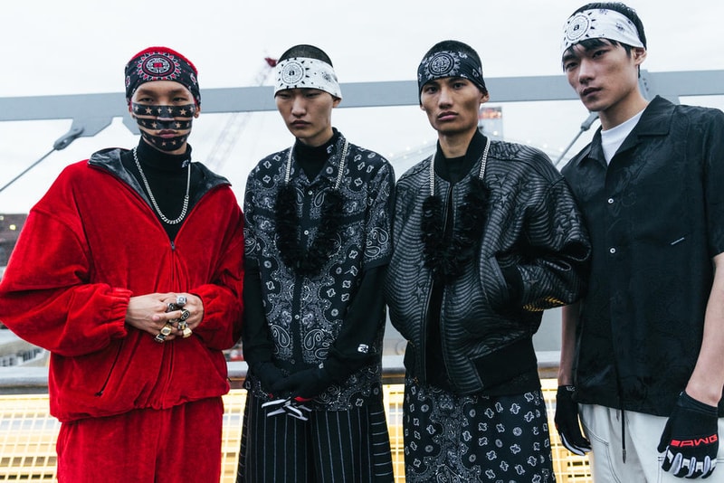 アメリカへの愛を表現した Alexander Wang の最新コレクションの舞台裏に潜入 『MTV』が一斉を風靡した2000年初頭を着想源に、ファッションの震源地であるアメリカが長い歴史で築き上げてきたスタイルの全てを凝縮 シンプルに“COLLECTION 1”というタイトルを掲げ、マンハッタンのハーバーサイド『Pier 19』で開催された〈Alexander Wang（アレキサンダー・ワン）〉の最新ランウェイは、Wangが想うアメリカンドリームと移民としてのルーツを表現したものだった。記録的大ヒットを記録したChildish Gambino（チャイルディッシュ・ガンビーノ）の“This is America”をクロージングソングに採用したショーは、Wangの「移民としてのルーツを持つアメリカ人のプライド」が来場に直に伝わったことだろう。だが、このコレクション自体は、何一つ混じり気のないアメリカ人らしさを称賛するものだったのである。  巨大な正方形の空間にそれと相反するヘヴィメタルのサウンドトラックが響きわたった今回のランウェイは、1980〜90年代の『MTV』や『Times Square』に訪れた観光客の服装など、現代アメリカファッションの原型を色濃く反映している。コレクションの根幹をなすクロップドパンツ、ローライダージーンズ、ケミカルなビブス、頭に巻かれたバンダナは、2000年の「MTV Video Music Awards」に登場したJennifer Lopez（ジェニファー・ロペス）がインスピレーションソース。また、〈adidas（アディダス）〉とのコラボレーションシューズはCrazy 97 EQT Elevationをベースのシルエットに採用しているほか、サングランスと米国への愛国心を感じさせるフェイスペイントも“COLLECTION 1”を象徴するものだった。その他にもオーバーサイズのジャージ、シルエットを誇張したレザージャケット、多様多種なレザーベルト、オンブレシャツ＆ショーツ、ペイズリープリントのボタンアップなど、コレクション全体をレッド/ブラックで統一した〈AW〉の最新コレクションは、ファッションの震源地としてアメリカが築き上げてきたものを凝縮していると言っても過言ではないだろう。  『HYPEBEAST』はそんな“COLLECTION 1”のバックステージに潜入することに成功。是非、ランウェイルックでは確認できないアパレルのディテールなどを上のフォトギャラリーからチェックしてみてほしい。  あわせて、先日デリバリーが完了した〈adidas Originals by Alexander Wang（アディダス オリジナルス バイ アレキサンダー ワン）〉の最新アイテム一覧もお見逃しなく。 HYPEBEAST