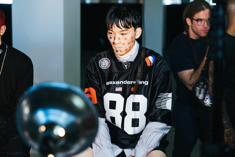 アメリカへの愛を表現した Alexander Wang の最新コレクションの舞台裏に潜入 『MTV』が一斉を風靡した2000年初頭を着想源に、ファッションの震源地であるアメリカが長い歴史で築き上げてきたスタイルの全てを凝縮 シンプルに“COLLECTION 1”というタイトルを掲げ、マンハッタンのハーバーサイド『Pier 19』で開催された〈Alexander Wang（アレキサンダー・ワン）〉の最新ランウェイは、Wangが想うアメリカンドリームと移民としてのルーツを表現したものだった。記録的大ヒットを記録したChildish Gambino（チャイルディッシュ・ガンビーノ）の“This is America”をクロージングソングに採用したショーは、Wangの「移民としてのルーツを持つアメリカ人のプライド」が来場に直に伝わったことだろう。だが、このコレクション自体は、何一つ混じり気のないアメリカ人らしさを称賛するものだったのである。  巨大な正方形の空間にそれと相反するヘヴィメタルのサウンドトラックが響きわたった今回のランウェイは、1980〜90年代の『MTV』や『Times Square』に訪れた観光客の服装など、現代アメリカファッションの原型を色濃く反映している。コレクションの根幹をなすクロップドパンツ、ローライダージーンズ、ケミカルなビブス、頭に巻かれたバンダナは、2000年の「MTV Video Music Awards」に登場したJennifer Lopez（ジェニファー・ロペス）がインスピレーションソース。また、〈adidas（アディダス）〉とのコラボレーションシューズはCrazy 97 EQT Elevationをベースのシルエットに採用しているほか、サングランスと米国への愛国心を感じさせるフェイスペイントも“COLLECTION 1”を象徴するものだった。その他にもオーバーサイズのジャージ、シルエットを誇張したレザージャケット、多様多種なレザーベルト、オンブレシャツ＆ショーツ、ペイズリープリントのボタンアップなど、コレクション全体をレッド/ブラックで統一した〈AW〉の最新コレクションは、ファッションの震源地としてアメリカが築き上げてきたものを凝縮していると言っても過言ではないだろう。  『HYPEBEAST』はそんな“COLLECTION 1”のバックステージに潜入することに成功。是非、ランウェイルックでは確認できないアパレルのディテールなどを上のフォトギャラリーからチェックしてみてほしい。  あわせて、先日デリバリーが完了した〈adidas Originals by Alexander Wang（アディダス オリジナルス バイ アレキサンダー ワン）〉の最新アイテム一覧もお見逃しなく。 HYPEBEAST