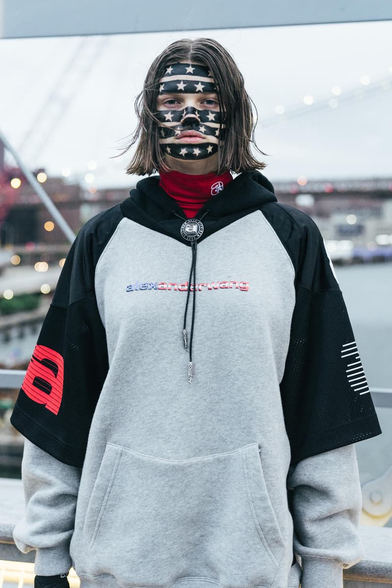 アメリカへの愛を表現した Alexander Wang の最新コレクションの舞台裏に潜入 『MTV』が一斉を風靡した2000年初頭を着想源に、ファッションの震源地であるアメリカが長い歴史で築き上げてきたスタイルの全てを凝縮 シンプルに“COLLECTION 1”というタイトルを掲げ、マンハッタンのハーバーサイド『Pier 19』で開催された〈Alexander Wang（アレキサンダー・ワン）〉の最新ランウェイは、Wangが想うアメリカンドリームと移民としてのルーツを表現したものだった。記録的大ヒットを記録したChildish Gambino（チャイルディッシュ・ガンビーノ）の“This is America”をクロージングソングに採用したショーは、Wangの「移民としてのルーツを持つアメリカ人のプライド」が来場に直に伝わったことだろう。だが、このコレクション自体は、何一つ混じり気のないアメリカ人らしさを称賛するものだったのである。  巨大な正方形の空間にそれと相反するヘヴィメタルのサウンドトラックが響きわたった今回のランウェイは、1980〜90年代の『MTV』や『Times Square』に訪れた観光客の服装など、現代アメリカファッションの原型を色濃く反映している。コレクションの根幹をなすクロップドパンツ、ローライダージーンズ、ケミカルなビブス、頭に巻かれたバンダナは、2000年の「MTV Video Music Awards」に登場したJennifer Lopez（ジェニファー・ロペス）がインスピレーションソース。また、〈adidas（アディダス）〉とのコラボレーションシューズはCrazy 97 EQT Elevationをベースのシルエットに採用しているほか、サングランスと米国への愛国心を感じさせるフェイスペイントも“COLLECTION 1”を象徴するものだった。その他にもオーバーサイズのジャージ、シルエットを誇張したレザージャケット、多様多種なレザーベルト、オンブレシャツ＆ショーツ、ペイズリープリントのボタンアップなど、コレクション全体をレッド/ブラックで統一した〈AW〉の最新コレクションは、ファッションの震源地としてアメリカが築き上げてきたものを凝縮していると言っても過言ではないだろう。  『HYPEBEAST』はそんな“COLLECTION 1”のバックステージに潜入することに成功。是非、ランウェイルックでは確認できないアパレルのディテールなどを上のフォトギャラリーからチェックしてみてほしい。  あわせて、先日デリバリーが完了した〈adidas Originals by Alexander Wang（アディダス オリジナルス バイ アレキサンダー ワン）〉の最新アイテム一覧もお見逃しなく。 HYPEBEAST