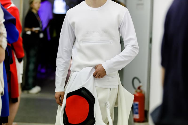 丸龍文人の帰還は、2019年春夏シーズン最大のトピックのひとつだった。〈COMME des GARÇONS（コム デ ギャルソン）〉退社から約2年の時を経て、同氏は自身の名を冠した〈FUMITO GANRYU（フミト ガンリュー）〉を「Pitti Uomo（ピッティ ウォモ）」の“Designer Project”で発表。幸運にも、『HYPEBEAST』はこの新たな船出となるランウェイの舞台裏に潜入する機会を得ることができた。  1stコレクションに言及する前に、〈GANRYU〉の時代を振り返ってみたい。シャツ、デニム、テーラードジャケットなど、ベースとなるカジュアルウェアは決して新鮮味を感じるものではない。だが、丸龍氏の手にかかれば、それらの洋服はモードに寄っていくのではなく、文字通り“昇華”されてしまうのだ。かつて『Union（ユニオン）』のChris Gibbs（クリス・ギブス）も「COMME des GARÇONSファミリーの中で最も完璧なブランドだ。なぜなら、GANRYUはストリートウェア、ワークウェア、ハイファッションを融合しているからである」と『BoF』の中で同氏のクリエイションを手放しに賞賛。それだけ、〈GANRYU〉はどこよりも早く、ランウェイからストリートにリーチしていたのだ。  〈FUMITO GANRYU〉のデビューコレクションは、会場に水の逆光写真が飾られた空間でお披露目を迎えた。ランウェイでは極限までクリーンに仕立てられたスポーツウェアが随所で登場し、カトリックの衣装を彷彿とさせるオーバーサイズのフーディや半透明のクリアベルトを採用したサンダルがキーピースに。そのシルエット美には誰しもが「シーンに丸龍文人が帰ってきた」と感じたことだろう。  〈FUMITO GANRYU〉初のコレクションの細部に迫るバックステージフォトは、上のフォトギャラリーから。取扱店舗などの詳細は、@fumitoganryuなどを含め、ブランドからのアップデートを待とう。  あわせて、先日閉幕したロンドンファッションウィーク・メンズ期間中に敢行したストリートスナップもお見逃しなく。