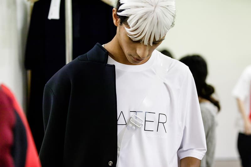 丸龍文人の帰還は、2019年春夏シーズン最大のトピックのひとつだった。〈COMME des GARÇONS（コム デ ギャルソン）〉退社から約2年の時を経て、同氏は自身の名を冠した〈FUMITO GANRYU（フミト ガンリュー）〉を「Pitti Uomo（ピッティ ウォモ）」の“Designer Project”で発表。幸運にも、『HYPEBEAST』はこの新たな船出となるランウェイの舞台裏に潜入する機会を得ることができた。  1stコレクションに言及する前に、〈GANRYU〉の時代を振り返ってみたい。シャツ、デニム、テーラードジャケットなど、ベースとなるカジュアルウェアは決して新鮮味を感じるものではない。だが、丸龍氏の手にかかれば、それらの洋服はモードに寄っていくのではなく、文字通り“昇華”されてしまうのだ。かつて『Union（ユニオン）』のChris Gibbs（クリス・ギブス）も「COMME des GARÇONSファミリーの中で最も完璧なブランドだ。なぜなら、GANRYUはストリートウェア、ワークウェア、ハイファッションを融合しているからである」と『BoF』の中で同氏のクリエイションを手放しに賞賛。それだけ、〈GANRYU〉はどこよりも早く、ランウェイからストリートにリーチしていたのだ。  〈FUMITO GANRYU〉のデビューコレクションは、会場に水の逆光写真が飾られた空間でお披露目を迎えた。ランウェイでは極限までクリーンに仕立てられたスポーツウェアが随所で登場し、カトリックの衣装を彷彿とさせるオーバーサイズのフーディや半透明のクリアベルトを採用したサンダルがキーピースに。そのシルエット美には誰しもが「シーンに丸龍文人が帰ってきた」と感じたことだろう。  〈FUMITO GANRYU〉初のコレクションの細部に迫るバックステージフォトは、上のフォトギャラリーから。取扱店舗などの詳細は、@fumitoganryuなどを含め、ブランドからのアップデートを待とう。  あわせて、先日閉幕したロンドンファッションウィーク・メンズ期間中に敢行したストリートスナップもお見逃しなく。