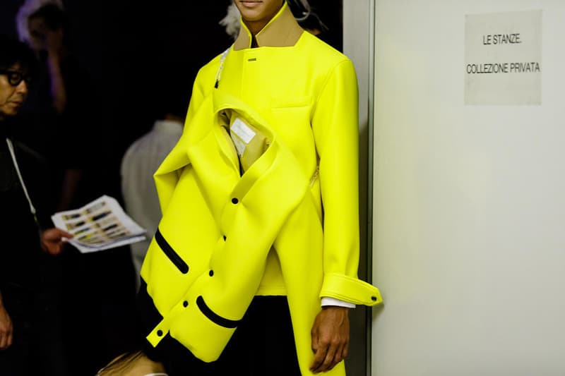 丸龍文人の帰還は、2019年春夏シーズン最大のトピックのひとつだった。〈COMME des GARÇONS（コム デ ギャルソン）〉退社から約2年の時を経て、同氏は自身の名を冠した〈FUMITO GANRYU（フミト ガンリュー）〉を「Pitti Uomo（ピッティ ウォモ）」の“Designer Project”で発表。幸運にも、『HYPEBEAST』はこの新たな船出となるランウェイの舞台裏に潜入する機会を得ることができた。  1stコレクションに言及する前に、〈GANRYU〉の時代を振り返ってみたい。シャツ、デニム、テーラードジャケットなど、ベースとなるカジュアルウェアは決して新鮮味を感じるものではない。だが、丸龍氏の手にかかれば、それらの洋服はモードに寄っていくのではなく、文字通り“昇華”されてしまうのだ。かつて『Union（ユニオン）』のChris Gibbs（クリス・ギブス）も「COMME des GARÇONSファミリーの中で最も完璧なブランドだ。なぜなら、GANRYUはストリートウェア、ワークウェア、ハイファッションを融合しているからである」と『BoF』の中で同氏のクリエイションを手放しに賞賛。それだけ、〈GANRYU〉はどこよりも早く、ランウェイからストリートにリーチしていたのだ。  〈FUMITO GANRYU〉のデビューコレクションは、会場に水の逆光写真が飾られた空間でお披露目を迎えた。ランウェイでは極限までクリーンに仕立てられたスポーツウェアが随所で登場し、カトリックの衣装を彷彿とさせるオーバーサイズのフーディや半透明のクリアベルトを採用したサンダルがキーピースに。そのシルエット美には誰しもが「シーンに丸龍文人が帰ってきた」と感じたことだろう。  〈FUMITO GANRYU〉初のコレクションの細部に迫るバックステージフォトは、上のフォトギャラリーから。取扱店舗などの詳細は、@fumitoganryuなどを含め、ブランドからのアップデートを待とう。  あわせて、先日閉幕したロンドンファッションウィーク・メンズ期間中に敢行したストリートスナップもお見逃しなく。