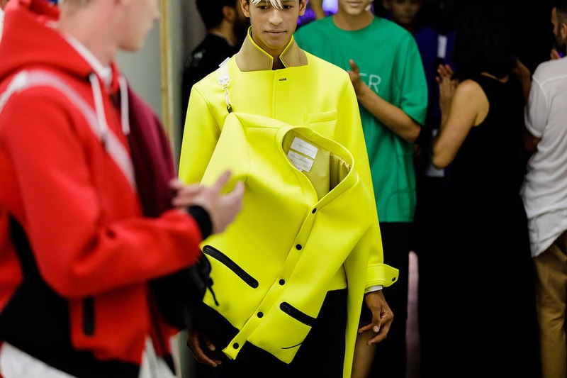 丸龍文人の帰還は、2019年春夏シーズン最大のトピックのひとつだった。〈COMME des GARÇONS（コム デ ギャルソン）〉退社から約2年の時を経て、同氏は自身の名を冠した〈FUMITO GANRYU（フミト ガンリュー）〉を「Pitti Uomo（ピッティ ウォモ）」の“Designer Project”で発表。幸運にも、『HYPEBEAST』はこの新たな船出となるランウェイの舞台裏に潜入する機会を得ることができた。  1stコレクションに言及する前に、〈GANRYU〉の時代を振り返ってみたい。シャツ、デニム、テーラードジャケットなど、ベースとなるカジュアルウェアは決して新鮮味を感じるものではない。だが、丸龍氏の手にかかれば、それらの洋服はモードに寄っていくのではなく、文字通り“昇華”されてしまうのだ。かつて『Union（ユニオン）』のChris Gibbs（クリス・ギブス）も「COMME des GARÇONSファミリーの中で最も完璧なブランドだ。なぜなら、GANRYUはストリートウェア、ワークウェア、ハイファッションを融合しているからである」と『BoF』の中で同氏のクリエイションを手放しに賞賛。それだけ、〈GANRYU〉はどこよりも早く、ランウェイからストリートにリーチしていたのだ。  〈FUMITO GANRYU〉のデビューコレクションは、会場に水の逆光写真が飾られた空間でお披露目を迎えた。ランウェイでは極限までクリーンに仕立てられたスポーツウェアが随所で登場し、カトリックの衣装を彷彿とさせるオーバーサイズのフーディや半透明のクリアベルトを採用したサンダルがキーピースに。そのシルエット美には誰しもが「シーンに丸龍文人が帰ってきた」と感じたことだろう。  〈FUMITO GANRYU〉初のコレクションの細部に迫るバックステージフォトは、上のフォトギャラリーから。取扱店舗などの詳細は、@fumitoganryuなどを含め、ブランドからのアップデートを待とう。  あわせて、先日閉幕したロンドンファッションウィーク・メンズ期間中に敢行したストリートスナップもお見逃しなく。