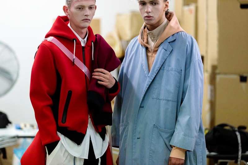 丸龍文人の帰還は、2019年春夏シーズン最大のトピックのひとつだった。〈COMME des GARÇONS（コム デ ギャルソン）〉退社から約2年の時を経て、同氏は自身の名を冠した〈FUMITO GANRYU（フミト ガンリュー）〉を「Pitti Uomo（ピッティ ウォモ）」の“Designer Project”で発表。幸運にも、『HYPEBEAST』はこの新たな船出となるランウェイの舞台裏に潜入する機会を得ることができた。  1stコレクションに言及する前に、〈GANRYU〉の時代を振り返ってみたい。シャツ、デニム、テーラードジャケットなど、ベースとなるカジュアルウェアは決して新鮮味を感じるものではない。だが、丸龍氏の手にかかれば、それらの洋服はモードに寄っていくのではなく、文字通り“昇華”されてしまうのだ。かつて『Union（ユニオン）』のChris Gibbs（クリス・ギブス）も「COMME des GARÇONSファミリーの中で最も完璧なブランドだ。なぜなら、GANRYUはストリートウェア、ワークウェア、ハイファッションを融合しているからである」と『BoF』の中で同氏のクリエイションを手放しに賞賛。それだけ、〈GANRYU〉はどこよりも早く、ランウェイからストリートにリーチしていたのだ。  〈FUMITO GANRYU〉のデビューコレクションは、会場に水の逆光写真が飾られた空間でお披露目を迎えた。ランウェイでは極限までクリーンに仕立てられたスポーツウェアが随所で登場し、カトリックの衣装を彷彿とさせるオーバーサイズのフーディや半透明のクリアベルトを採用したサンダルがキーピースに。そのシルエット美には誰しもが「シーンに丸龍文人が帰ってきた」と感じたことだろう。  〈FUMITO GANRYU〉初のコレクションの細部に迫るバックステージフォトは、上のフォトギャラリーから。取扱店舗などの詳細は、@fumitoganryuなどを含め、ブランドからのアップデートを待とう。  あわせて、先日閉幕したロンドンファッションウィーク・メンズ期間中に敢行したストリートスナップもお見逃しなく。