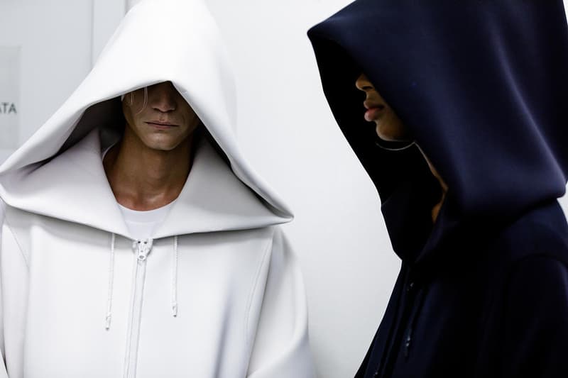 丸龍文人の帰還は、2019年春夏シーズン最大のトピックのひとつだった。〈COMME des GARÇONS（コム デ ギャルソン）〉退社から約2年の時を経て、同氏は自身の名を冠した〈FUMITO GANRYU（フミト ガンリュー）〉を「Pitti Uomo（ピッティ ウォモ）」の“Designer Project”で発表。幸運にも、『HYPEBEAST』はこの新たな船出となるランウェイの舞台裏に潜入する機会を得ることができた。  1stコレクションに言及する前に、〈GANRYU〉の時代を振り返ってみたい。シャツ、デニム、テーラードジャケットなど、ベースとなるカジュアルウェアは決して新鮮味を感じるものではない。だが、丸龍氏の手にかかれば、それらの洋服はモードに寄っていくのではなく、文字通り“昇華”されてしまうのだ。かつて『Union（ユニオン）』のChris Gibbs（クリス・ギブス）も「COMME des GARÇONSファミリーの中で最も完璧なブランドだ。なぜなら、GANRYUはストリートウェア、ワークウェア、ハイファッションを融合しているからである」と『BoF』の中で同氏のクリエイションを手放しに賞賛。それだけ、〈GANRYU〉はどこよりも早く、ランウェイからストリートにリーチしていたのだ。  〈FUMITO GANRYU〉のデビューコレクションは、会場に水の逆光写真が飾られた空間でお披露目を迎えた。ランウェイでは極限までクリーンに仕立てられたスポーツウェアが随所で登場し、カトリックの衣装を彷彿とさせるオーバーサイズのフーディや半透明のクリアベルトを採用したサンダルがキーピースに。そのシルエット美には誰しもが「シーンに丸龍文人が帰ってきた」と感じたことだろう。  〈FUMITO GANRYU〉初のコレクションの細部に迫るバックステージフォトは、上のフォトギャラリーから。取扱店舗などの詳細は、@fumitoganryuなどを含め、ブランドからのアップデートを待とう。  あわせて、先日閉幕したロンドンファッションウィーク・メンズ期間中に敢行したストリートスナップもお見逃しなく。