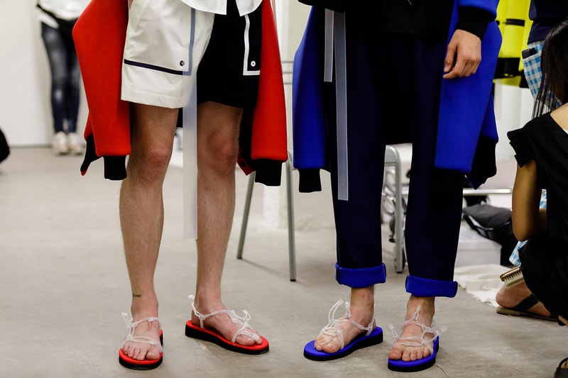 丸龍文人の帰還は、2019年春夏シーズン最大のトピックのひとつだった。〈COMME des GARÇONS（コム デ ギャルソン）〉退社から約2年の時を経て、同氏は自身の名を冠した〈FUMITO GANRYU（フミト ガンリュー）〉を「Pitti Uomo（ピッティ ウォモ）」の“Designer Project”で発表。幸運にも、『HYPEBEAST』はこの新たな船出となるランウェイの舞台裏に潜入する機会を得ることができた。  1stコレクションに言及する前に、〈GANRYU〉の時代を振り返ってみたい。シャツ、デニム、テーラードジャケットなど、ベースとなるカジュアルウェアは決して新鮮味を感じるものではない。だが、丸龍氏の手にかかれば、それらの洋服はモードに寄っていくのではなく、文字通り“昇華”されてしまうのだ。かつて『Union（ユニオン）』のChris Gibbs（クリス・ギブス）も「COMME des GARÇONSファミリーの中で最も完璧なブランドだ。なぜなら、GANRYUはストリートウェア、ワークウェア、ハイファッションを融合しているからである」と『BoF』の中で同氏のクリエイションを手放しに賞賛。それだけ、〈GANRYU〉はどこよりも早く、ランウェイからストリートにリーチしていたのだ。  〈FUMITO GANRYU〉のデビューコレクションは、会場に水の逆光写真が飾られた空間でお披露目を迎えた。ランウェイでは極限までクリーンに仕立てられたスポーツウェアが随所で登場し、カトリックの衣装を彷彿とさせるオーバーサイズのフーディや半透明のクリアベルトを採用したサンダルがキーピースに。そのシルエット美には誰しもが「シーンに丸龍文人が帰ってきた」と感じたことだろう。  〈FUMITO GANRYU〉初のコレクションの細部に迫るバックステージフォトは、上のフォトギャラリーから。取扱店舗などの詳細は、@fumitoganryuなどを含め、ブランドからのアップデートを待とう。  あわせて、先日閉幕したロンドンファッションウィーク・メンズ期間中に敢行したストリートスナップもお見逃しなく。