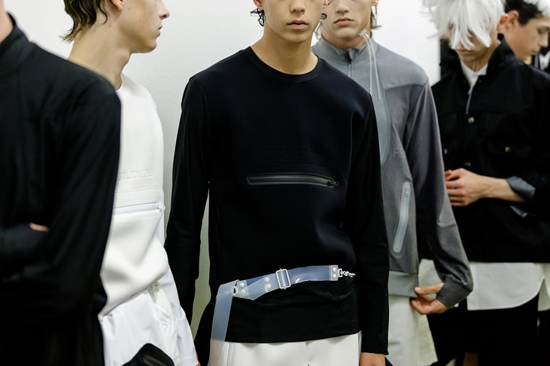 丸龍文人の帰還は、2019年春夏シーズン最大のトピックのひとつだった。〈COMME des GARÇONS（コム デ ギャルソン）〉退社から約2年の時を経て、同氏は自身の名を冠した〈FUMITO GANRYU（フミト ガンリュー）〉を「Pitti Uomo（ピッティ ウォモ）」の“Designer Project”で発表。幸運にも、『HYPEBEAST』はこの新たな船出となるランウェイの舞台裏に潜入する機会を得ることができた。  1stコレクションに言及する前に、〈GANRYU〉の時代を振り返ってみたい。シャツ、デニム、テーラードジャケットなど、ベースとなるカジュアルウェアは決して新鮮味を感じるものではない。だが、丸龍氏の手にかかれば、それらの洋服はモードに寄っていくのではなく、文字通り“昇華”されてしまうのだ。かつて『Union（ユニオン）』のChris Gibbs（クリス・ギブス）も「COMME des GARÇONSファミリーの中で最も完璧なブランドだ。なぜなら、GANRYUはストリートウェア、ワークウェア、ハイファッションを融合しているからである」と『BoF』の中で同氏のクリエイションを手放しに賞賛。それだけ、〈GANRYU〉はどこよりも早く、ランウェイからストリートにリーチしていたのだ。  〈FUMITO GANRYU〉のデビューコレクションは、会場に水の逆光写真が飾られた空間でお披露目を迎えた。ランウェイでは極限までクリーンに仕立てられたスポーツウェアが随所で登場し、カトリックの衣装を彷彿とさせるオーバーサイズのフーディや半透明のクリアベルトを採用したサンダルがキーピースに。そのシルエット美には誰しもが「シーンに丸龍文人が帰ってきた」と感じたことだろう。  〈FUMITO GANRYU〉初のコレクションの細部に迫るバックステージフォトは、上のフォトギャラリーから。取扱店舗などの詳細は、@fumitoganryuなどを含め、ブランドからのアップデートを待とう。  あわせて、先日閉幕したロンドンファッションウィーク・メンズ期間中に敢行したストリートスナップもお見逃しなく。