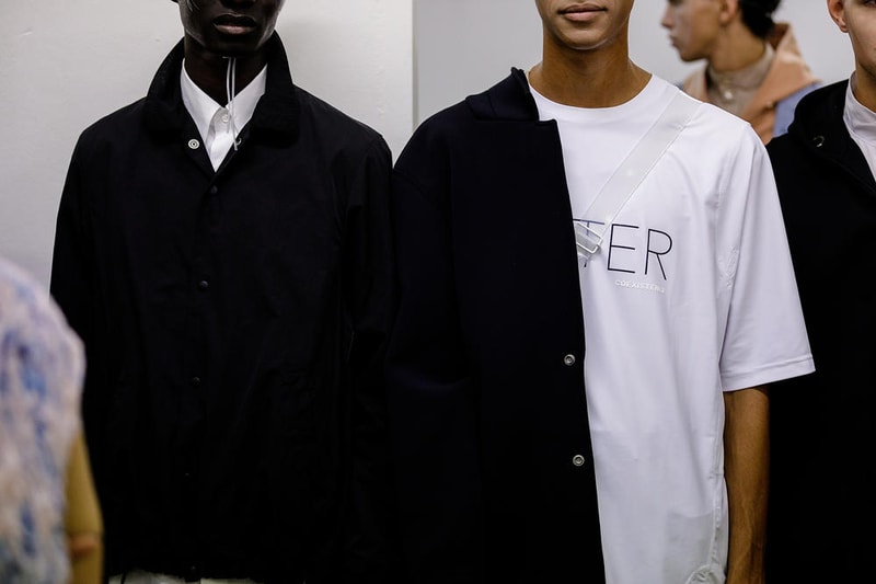 丸龍文人の帰還は、2019年春夏シーズン最大のトピックのひとつだった。〈COMME des GARÇONS（コム デ ギャルソン）〉退社から約2年の時を経て、同氏は自身の名を冠した〈FUMITO GANRYU（フミト ガンリュー）〉を「Pitti Uomo（ピッティ ウォモ）」の“Designer Project”で発表。幸運にも、『HYPEBEAST』はこの新たな船出となるランウェイの舞台裏に潜入する機会を得ることができた。  1stコレクションに言及する前に、〈GANRYU〉の時代を振り返ってみたい。シャツ、デニム、テーラードジャケットなど、ベースとなるカジュアルウェアは決して新鮮味を感じるものではない。だが、丸龍氏の手にかかれば、それらの洋服はモードに寄っていくのではなく、文字通り“昇華”されてしまうのだ。かつて『Union（ユニオン）』のChris Gibbs（クリス・ギブス）も「COMME des GARÇONSファミリーの中で最も完璧なブランドだ。なぜなら、GANRYUはストリートウェア、ワークウェア、ハイファッションを融合しているからである」と『BoF』の中で同氏のクリエイションを手放しに賞賛。それだけ、〈GANRYU〉はどこよりも早く、ランウェイからストリートにリーチしていたのだ。  〈FUMITO GANRYU〉のデビューコレクションは、会場に水の逆光写真が飾られた空間でお披露目を迎えた。ランウェイでは極限までクリーンに仕立てられたスポーツウェアが随所で登場し、カトリックの衣装を彷彿とさせるオーバーサイズのフーディや半透明のクリアベルトを採用したサンダルがキーピースに。そのシルエット美には誰しもが「シーンに丸龍文人が帰ってきた」と感じたことだろう。  〈FUMITO GANRYU〉初のコレクションの細部に迫るバックステージフォトは、上のフォトギャラリーから。取扱店舗などの詳細は、@fumitoganryuなどを含め、ブランドからのアップデートを待とう。  あわせて、先日閉幕したロンドンファッションウィーク・メンズ期間中に敢行したストリートスナップもお見逃しなく。