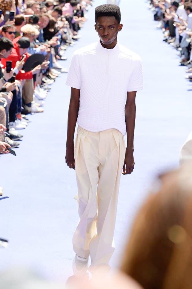 ヴァージル・アブローが手がけた Louis Vuitton 2019年春夏コレクションが遂にお披露目 ファッション界に後世まで語り継がれる歴史的1ページが追加される 〈Louis Vuitton(ルイ ヴィトン)〉がVirgil Abloh(ヴァージル・アブロー)のアーティスティック・ディレクター就任を発表してから早3ヶ月、遂に今をときめくデザイナーの〈LV〉デビューとなる2019年春夏コレクションがお披露目を迎えた。 晴天のパレ・ロワイヤル庭園には、Kanye West(カニエ・ウェスト)とその妻Kim Kardashian(キム・カーダシアン)や、Rihanna(リアーナ)、Kylie Jenner(カイリー・ジェンナー)、A$AP Rocky(エイサップ・ロッキー)、村上隆など、Virgilの友人でもある豪華ゲストが集結。ヒップホップとジャズを繋ぐ成長著しいカルテット、BadBadNotGood(バッドバッドノットグッド)がサウンドトラックを提供したランウェイには、Kid Cudi(キッド・カディ)、Dev Hynes(デヴ・ハインズ)、A$AP Nast(エイサップ・ナスト)、Playboi Carti(プレイボーイ・カルティ)、Theophilus London(テオフィルス・ロンドン)、そして〈Palace(パレス)〉よりLucien Clarke(ルシアン・クラーク)とBlondey McCoy(ブロンディ・マッコイ)らがモデルに起用された。 全56体のルックでは、〈Off-White™️(オフホワイト)〉の党首の真髄である“ラグジュアリーとストリートの融合”が力強さとともに解き放たれた。タイダイ、フローラルパターン、来年80周年を迎える映画『オズの魔法使い』とのコラボレーションなど、必要最小限でありながらも視覚的魅力を放つアイテムがコレクションにエンターテイメント性を付与し、ドラマチックな雰囲気を醸すそのランウェイでは、ルーズフィットのパンツやユーティリティベスト、シアーシャツ、フーディ、仕立ての良いトレンチコートなどがカラーパレットごとに紹介されていく。また、昨日Virgil本人が先行公開したバスケットシューズ風の一足を含め、フットウェアはハイトップシルエットを中心に構成され、上質なドレスシューズもシューレースの配色で遊びをプラス。加えて、〈Louis Vuitton〉の象徴とも言えるラゲージ類は、モノグラムをエンボス加工した半透明の素材やチェーンの斬新な組み合わせにより、良い意味でモードの品格を削ぎ落とした仕上がりにより、観衆の目を釘付けにした。 大喝采の中で迎えたフィナーレではVirgilが涙を流しながら花道を歩き抜け、自身の師匠であるKanyeと熱い抱擁を交わすシーンも。そんな〈Louis Vuitton〉、そしてVirgilの歴史的一幕を是非、上のフォトギャラリーからチェックしてみてはいかがだろうか。