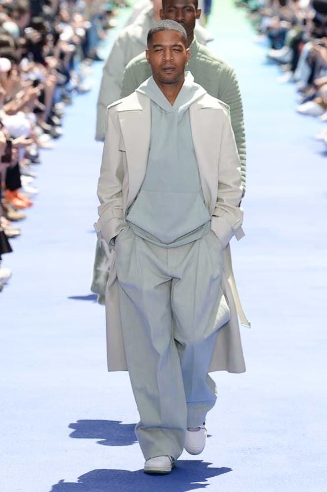 ヴァージル・アブローが手がけた Louis Vuitton 2019年春夏コレクションが遂にお披露目 ファッション界に後世まで語り継がれる歴史的1ページが追加される 〈Louis Vuitton(ルイ ヴィトン)〉がVirgil Abloh(ヴァージル・アブロー)のアーティスティック・ディレクター就任を発表してから早3ヶ月、遂に今をときめくデザイナーの〈LV〉デビューとなる2019年春夏コレクションがお披露目を迎えた。 晴天のパレ・ロワイヤル庭園には、Kanye West(カニエ・ウェスト)とその妻Kim Kardashian(キム・カーダシアン)や、Rihanna(リアーナ)、Kylie Jenner(カイリー・ジェンナー)、A$AP Rocky(エイサップ・ロッキー)、村上隆など、Virgilの友人でもある豪華ゲストが集結。ヒップホップとジャズを繋ぐ成長著しいカルテット、BadBadNotGood(バッドバッドノットグッド)がサウンドトラックを提供したランウェイには、Kid Cudi(キッド・カディ)、Dev Hynes(デヴ・ハインズ)、A$AP Nast(エイサップ・ナスト)、Playboi Carti(プレイボーイ・カルティ)、Theophilus London(テオフィルス・ロンドン)、そして〈Palace(パレス)〉よりLucien Clarke(ルシアン・クラーク)とBlondey McCoy(ブロンディ・マッコイ)らがモデルに起用された。 全56体のルックでは、〈Off-White™️(オフホワイト)〉の党首の真髄である“ラグジュアリーとストリートの融合”が力強さとともに解き放たれた。タイダイ、フローラルパターン、来年80周年を迎える映画『オズの魔法使い』とのコラボレーションなど、必要最小限でありながらも視覚的魅力を放つアイテムがコレクションにエンターテイメント性を付与し、ドラマチックな雰囲気を醸すそのランウェイでは、ルーズフィットのパンツやユーティリティベスト、シアーシャツ、フーディ、仕立ての良いトレンチコートなどがカラーパレットごとに紹介されていく。また、昨日Virgil本人が先行公開したバスケットシューズ風の一足を含め、フットウェアはハイトップシルエットを中心に構成され、上質なドレスシューズもシューレースの配色で遊びをプラス。加えて、〈Louis Vuitton〉の象徴とも言えるラゲージ類は、モノグラムをエンボス加工した半透明の素材やチェーンの斬新な組み合わせにより、良い意味でモードの品格を削ぎ落とした仕上がりにより、観衆の目を釘付けにした。 大喝采の中で迎えたフィナーレではVirgilが涙を流しながら花道を歩き抜け、自身の師匠であるKanyeと熱い抱擁を交わすシーンも。そんな〈Louis Vuitton〉、そしてVirgilの歴史的一幕を是非、上のフォトギャラリーからチェックしてみてはいかがだろうか。