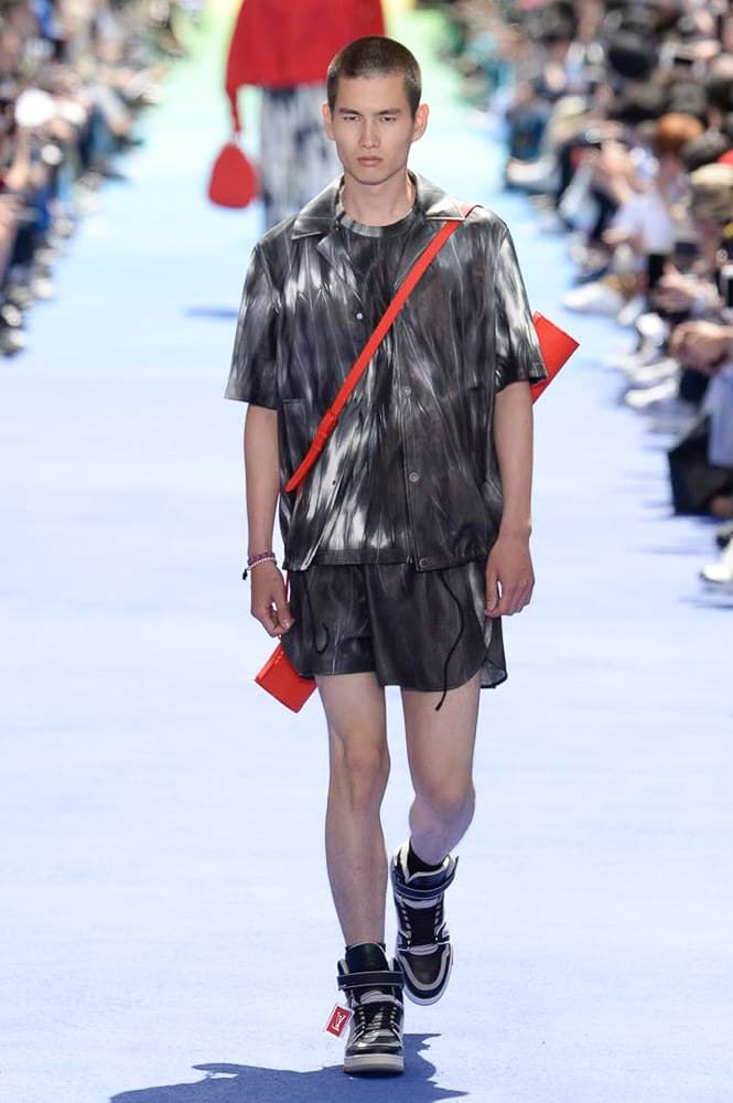 ヴァージル・アブローが手がけた Louis Vuitton 2019年春夏コレクションが遂にお披露目 ファッション界に後世まで語り継がれる歴史的1ページが追加される 〈Louis Vuitton(ルイ ヴィトン)〉がVirgil Abloh(ヴァージル・アブロー)のアーティスティック・ディレクター就任を発表してから早3ヶ月、遂に今をときめくデザイナーの〈LV〉デビューとなる2019年春夏コレクションがお披露目を迎えた。 晴天のパレ・ロワイヤル庭園には、Kanye West(カニエ・ウェスト)とその妻Kim Kardashian(キム・カーダシアン)や、Rihanna(リアーナ)、Kylie Jenner(カイリー・ジェンナー)、A$AP Rocky(エイサップ・ロッキー)、村上隆など、Virgilの友人でもある豪華ゲストが集結。ヒップホップとジャズを繋ぐ成長著しいカルテット、BadBadNotGood(バッドバッドノットグッド)がサウンドトラックを提供したランウェイには、Kid Cudi(キッド・カディ)、Dev Hynes(デヴ・ハインズ)、A$AP Nast(エイサップ・ナスト)、Playboi Carti(プレイボーイ・カルティ)、Theophilus London(テオフィルス・ロンドン)、そして〈Palace(パレス)〉よりLucien Clarke(ルシアン・クラーク)とBlondey McCoy(ブロンディ・マッコイ)らがモデルに起用された。 全56体のルックでは、〈Off-White™️(オフホワイト)〉の党首の真髄である“ラグジュアリーとストリートの融合”が力強さとともに解き放たれた。タイダイ、フローラルパターン、来年80周年を迎える映画『オズの魔法使い』とのコラボレーションなど、必要最小限でありながらも視覚的魅力を放つアイテムがコレクションにエンターテイメント性を付与し、ドラマチックな雰囲気を醸すそのランウェイでは、ルーズフィットのパンツやユーティリティベスト、シアーシャツ、フーディ、仕立ての良いトレンチコートなどがカラーパレットごとに紹介されていく。また、昨日Virgil本人が先行公開したバスケットシューズ風の一足を含め、フットウェアはハイトップシルエットを中心に構成され、上質なドレスシューズもシューレースの配色で遊びをプラス。加えて、〈Louis Vuitton〉の象徴とも言えるラゲージ類は、モノグラムをエンボス加工した半透明の素材やチェーンの斬新な組み合わせにより、良い意味でモードの品格を削ぎ落とした仕上がりにより、観衆の目を釘付けにした。 大喝采の中で迎えたフィナーレではVirgilが涙を流しながら花道を歩き抜け、自身の師匠であるKanyeと熱い抱擁を交わすシーンも。そんな〈Louis Vuitton〉、そしてVirgilの歴史的一幕を是非、上のフォトギャラリーからチェックしてみてはいかがだろうか。
