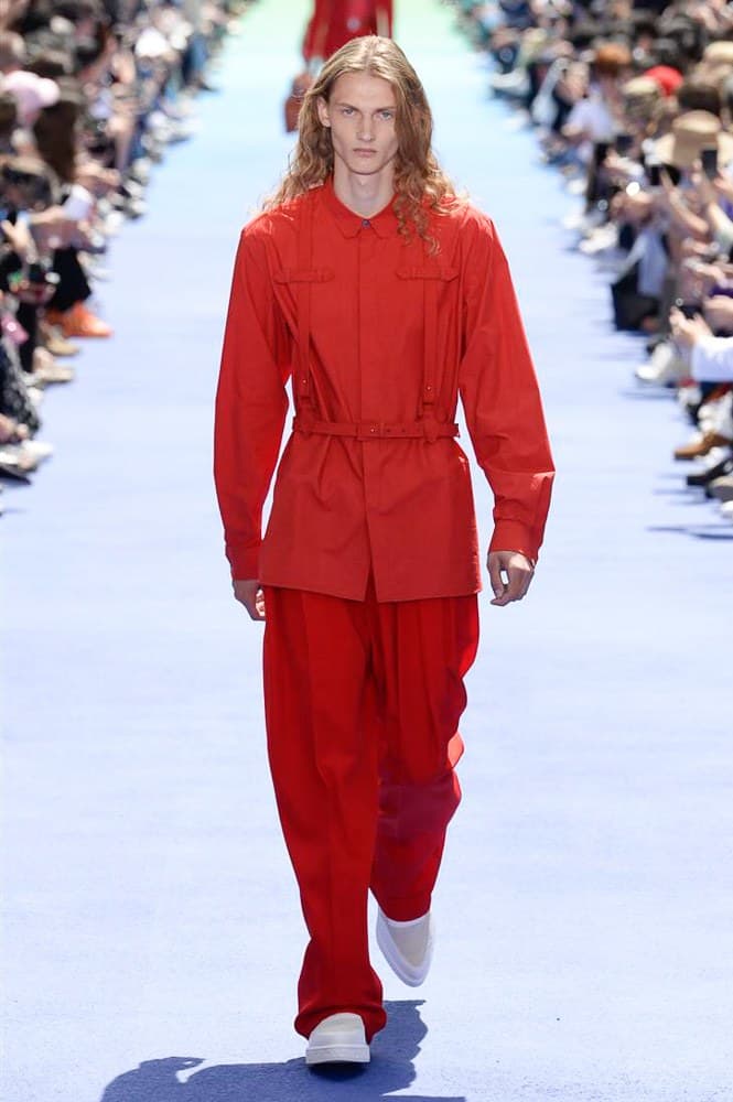 ヴァージル・アブローが手がけた Louis Vuitton 2019年春夏コレクションが遂にお披露目 ファッション界に後世まで語り継がれる歴史的1ページが追加される 〈Louis Vuitton(ルイ ヴィトン)〉がVirgil Abloh(ヴァージル・アブロー)のアーティスティック・ディレクター就任を発表してから早3ヶ月、遂に今をときめくデザイナーの〈LV〉デビューとなる2019年春夏コレクションがお披露目を迎えた。 晴天のパレ・ロワイヤル庭園には、Kanye West(カニエ・ウェスト)とその妻Kim Kardashian(キム・カーダシアン)や、Rihanna(リアーナ)、Kylie Jenner(カイリー・ジェンナー)、A$AP Rocky(エイサップ・ロッキー)、村上隆など、Virgilの友人でもある豪華ゲストが集結。ヒップホップとジャズを繋ぐ成長著しいカルテット、BadBadNotGood(バッドバッドノットグッド)がサウンドトラックを提供したランウェイには、Kid Cudi(キッド・カディ)、Dev Hynes(デヴ・ハインズ)、A$AP Nast(エイサップ・ナスト)、Playboi Carti(プレイボーイ・カルティ)、Theophilus London(テオフィルス・ロンドン)、そして〈Palace(パレス)〉よりLucien Clarke(ルシアン・クラーク)とBlondey McCoy(ブロンディ・マッコイ)らがモデルに起用された。 全56体のルックでは、〈Off-White™️(オフホワイト)〉の党首の真髄である“ラグジュアリーとストリートの融合”が力強さとともに解き放たれた。タイダイ、フローラルパターン、来年80周年を迎える映画『オズの魔法使い』とのコラボレーションなど、必要最小限でありながらも視覚的魅力を放つアイテムがコレクションにエンターテイメント性を付与し、ドラマチックな雰囲気を醸すそのランウェイでは、ルーズフィットのパンツやユーティリティベスト、シアーシャツ、フーディ、仕立ての良いトレンチコートなどがカラーパレットごとに紹介されていく。また、昨日Virgil本人が先行公開したバスケットシューズ風の一足を含め、フットウェアはハイトップシルエットを中心に構成され、上質なドレスシューズもシューレースの配色で遊びをプラス。加えて、〈Louis Vuitton〉の象徴とも言えるラゲージ類は、モノグラムをエンボス加工した半透明の素材やチェーンの斬新な組み合わせにより、良い意味でモードの品格を削ぎ落とした仕上がりにより、観衆の目を釘付けにした。 大喝采の中で迎えたフィナーレではVirgilが涙を流しながら花道を歩き抜け、自身の師匠であるKanyeと熱い抱擁を交わすシーンも。そんな〈Louis Vuitton〉、そしてVirgilの歴史的一幕を是非、上のフォトギャラリーからチェックしてみてはいかがだろうか。