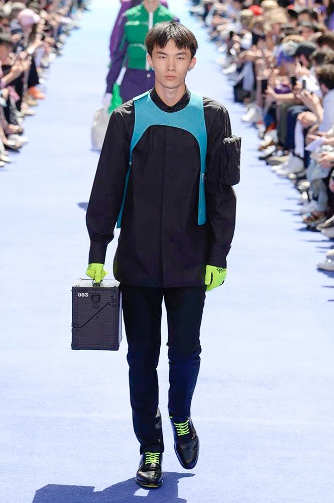 ヴァージル・アブローが手がけた Louis Vuitton 2019年春夏コレクションが遂にお披露目 ファッション界に後世まで語り継がれる歴史的1ページが追加される 〈Louis Vuitton（ルイ ヴィトン）〉がVirgil Abloh（ヴァージル・アブロー）のアーティスティック・ディレクター就任を発表してから早3ヶ月、遂に今をときめくデザイナーの〈LV〉デビューとなる2019年春夏コレクションがお披露目を迎えた。  晴天のパレ・ロワイヤル庭園には、Kanye West（カニエ・ウェスト）とその妻Kim Kardashian（キム・カーダシアン）や、Rihanna（リアーナ）、Kylie Jenner（カイリー・ジェンナー）、A$AP Rocky（エイサップ・ロッキー）、村上隆など、Virgilの友人でもある豪華ゲストが集結。ヒップホップとジャズを繋ぐ成長著しいカルテット、BadBadNotGood（バッドバッドノットグッド）がサウンドトラックを提供したランウェイには、Kid Cudi（キッド・カディ）、Dev Hynes（デヴ・ハインズ）、A$AP Nast（エイサップ・ナスト）、Playboi Carti（プレイボーイ・カルティ）、Theophilus London（テオフィルス・ロンドン）、そして〈Palace（パレス）〉よりLucien Clarke（ルシアン・クラーク）とBlondey McCoy（ブロンディ・マッコイ）らがモデルに起用された。  全56体のルックでは、〈Off-White™️（オフホワイト）〉の党首の真髄である“ラグジュアリーとストリートの融合”が力強さとともに解き放たれた。タイダイ、フローラルパターン、来年80周年を迎える映画『オズの魔法使い』とのコラボレーションなど、必要最小限でありながらも視覚的魅力を放つアイテムがコレクションにエンターテイメント性を付与し、ドラマチックな雰囲気を醸すそのランウェイでは、ルーズフィットのパンツやユーティリティベスト、シアーシャツ、フーディ、仕立ての良いトレンチコートなどがカラーパレットごとに紹介されていく。また、昨日Virgil本人が先行公開したバスケットシューズ風の一足を含め、フットウェアはハイトップシルエットを中心に構成され、上質なドレスシューズもシューレースの配色で遊びをプラス。加えて、〈Louis Vuitton〉の象徴とも言えるラゲージ類は、モノグラムをエンボス加工した半透明の素材やチェーンの斬新な組み合わせにより、良い意味でモードの品格を削ぎ落とした仕上がりにより、観衆の目を釘付けにした。  大喝采の中で迎えたフィナーレではVirgilが涙を流しながら花道を歩き抜け、自身の師匠であるKanyeと熱い抱擁を交わすシーンも。そんな〈Louis Vuitton〉、そしてVirgilの歴史的一幕を是非、上のフォトギャラリーからチェックしてみてはいかがだろうか。