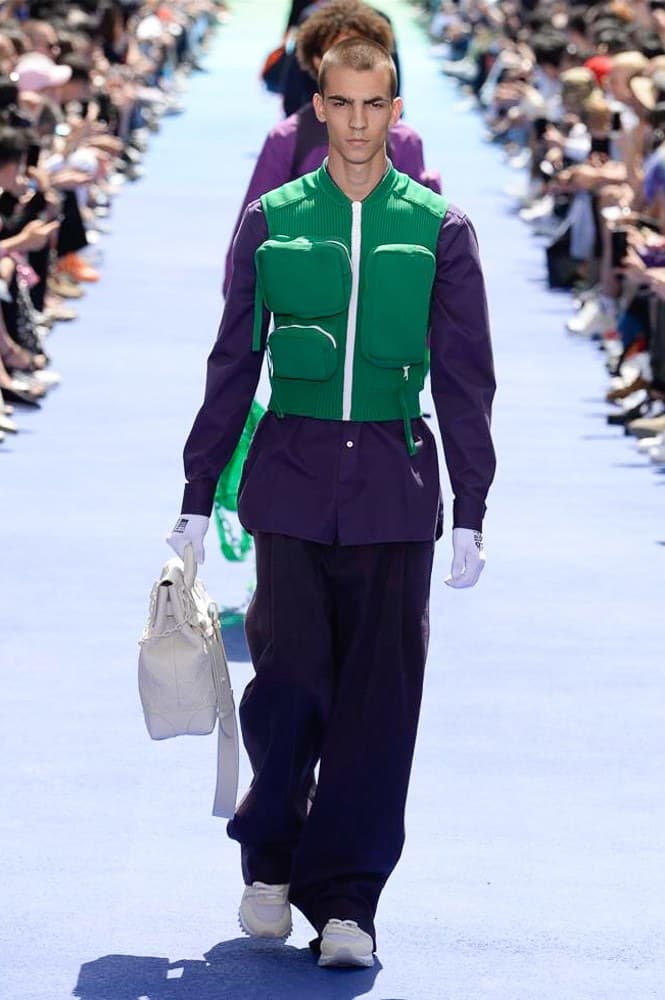 ヴァージル・アブローが手がけた Louis Vuitton 2019年春夏コレクションが遂にお披露目 ファッション界に後世まで語り継がれる歴史的1ページが追加される 〈Louis Vuitton(ルイ ヴィトン)〉がVirgil Abloh(ヴァージル・アブロー)のアーティスティック・ディレクター就任を発表してから早3ヶ月、遂に今をときめくデザイナーの〈LV〉デビューとなる2019年春夏コレクションがお披露目を迎えた。 晴天のパレ・ロワイヤル庭園には、Kanye West(カニエ・ウェスト)とその妻Kim Kardashian(キム・カーダシアン)や、Rihanna(リアーナ)、Kylie Jenner(カイリー・ジェンナー)、A$AP Rocky(エイサップ・ロッキー)、村上隆など、Virgilの友人でもある豪華ゲストが集結。ヒップホップとジャズを繋ぐ成長著しいカルテット、BadBadNotGood(バッドバッドノットグッド)がサウンドトラックを提供したランウェイには、Kid Cudi(キッド・カディ)、Dev Hynes(デヴ・ハインズ)、A$AP Nast(エイサップ・ナスト)、Playboi Carti(プレイボーイ・カルティ)、Theophilus London(テオフィルス・ロンドン)、そして〈Palace(パレス)〉よりLucien Clarke(ルシアン・クラーク)とBlondey McCoy(ブロンディ・マッコイ)らがモデルに起用された。 全56体のルックでは、〈Off-White™️(オフホワイト)〉の党首の真髄である“ラグジュアリーとストリートの融合”が力強さとともに解き放たれた。タイダイ、フローラルパターン、来年80周年を迎える映画『オズの魔法使い』とのコラボレーションなど、必要最小限でありながらも視覚的魅力を放つアイテムがコレクションにエンターテイメント性を付与し、ドラマチックな雰囲気を醸すそのランウェイでは、ルーズフィットのパンツやユーティリティベスト、シアーシャツ、フーディ、仕立ての良いトレンチコートなどがカラーパレットごとに紹介されていく。また、昨日Virgil本人が先行公開したバスケットシューズ風の一足を含め、フットウェアはハイトップシルエットを中心に構成され、上質なドレスシューズもシューレースの配色で遊びをプラス。加えて、〈Louis Vuitton〉の象徴とも言えるラゲージ類は、モノグラムをエンボス加工した半透明の素材やチェーンの斬新な組み合わせにより、良い意味でモードの品格を削ぎ落とした仕上がりにより、観衆の目を釘付けにした。 大喝采の中で迎えたフィナーレではVirgilが涙を流しながら花道を歩き抜け、自身の師匠であるKanyeと熱い抱擁を交わすシーンも。そんな〈Louis Vuitton〉、そしてVirgilの歴史的一幕を是非、上のフォトギャラリーからチェックしてみてはいかがだろうか。
