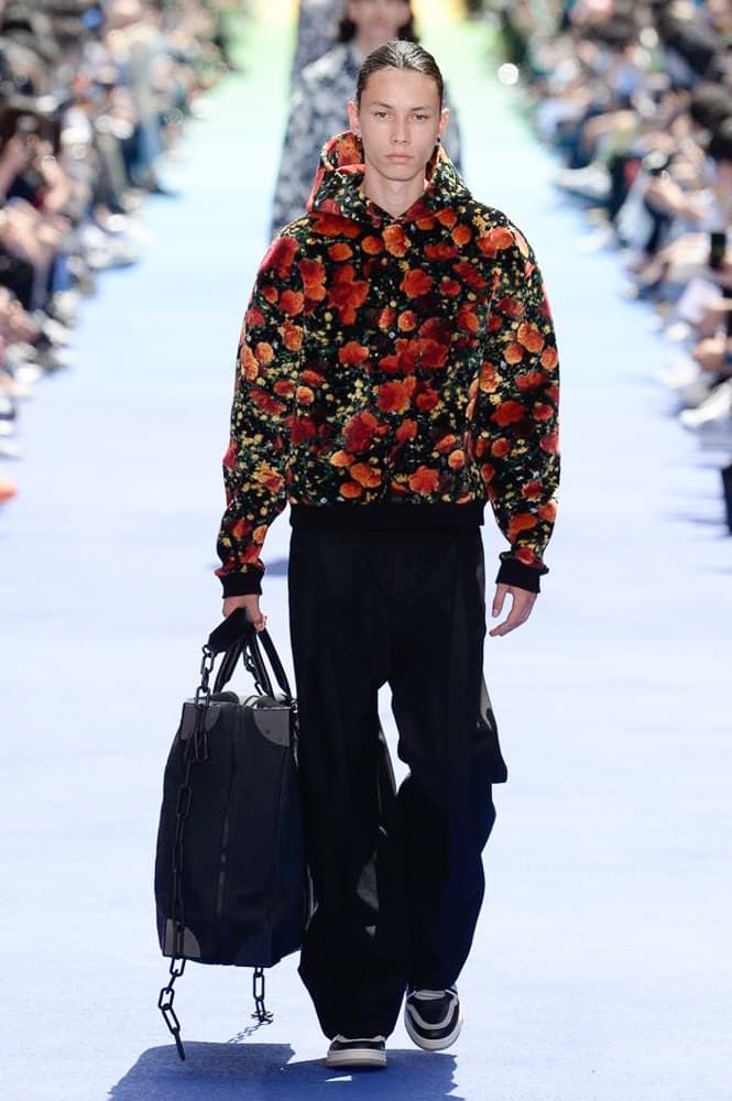 ヴァージル・アブローが手がけた Louis Vuitton 2019年春夏コレクションが遂にお披露目 ファッション界に後世まで語り継がれる歴史的1ページが追加される 〈Louis Vuitton（ルイ ヴィトン）〉がVirgil Abloh（ヴァージル・アブロー）のアーティスティック・ディレクター就任を発表してから早3ヶ月、遂に今をときめくデザイナーの〈LV〉デビューとなる2019年春夏コレクションがお披露目を迎えた。  晴天のパレ・ロワイヤル庭園には、Kanye West（カニエ・ウェスト）とその妻Kim Kardashian（キム・カーダシアン）や、Rihanna（リアーナ）、Kylie Jenner（カイリー・ジェンナー）、A$AP Rocky（エイサップ・ロッキー）、村上隆など、Virgilの友人でもある豪華ゲストが集結。ヒップホップとジャズを繋ぐ成長著しいカルテット、BadBadNotGood（バッドバッドノットグッド）がサウンドトラックを提供したランウェイには、Kid Cudi（キッド・カディ）、Dev Hynes（デヴ・ハインズ）、A$AP Nast（エイサップ・ナスト）、Playboi Carti（プレイボーイ・カルティ）、Theophilus London（テオフィルス・ロンドン）、そして〈Palace（パレス）〉よりLucien Clarke（ルシアン・クラーク）とBlondey McCoy（ブロンディ・マッコイ）らがモデルに起用された。  全56体のルックでは、〈Off-White™️（オフホワイト）〉の党首の真髄である“ラグジュアリーとストリートの融合”が力強さとともに解き放たれた。タイダイ、フローラルパターン、来年80周年を迎える映画『オズの魔法使い』とのコラボレーションなど、必要最小限でありながらも視覚的魅力を放つアイテムがコレクションにエンターテイメント性を付与し、ドラマチックな雰囲気を醸すそのランウェイでは、ルーズフィットのパンツやユーティリティベスト、シアーシャツ、フーディ、仕立ての良いトレンチコートなどがカラーパレットごとに紹介されていく。また、昨日Virgil本人が先行公開したバスケットシューズ風の一足を含め、フットウェアはハイトップシルエットを中心に構成され、上質なドレスシューズもシューレースの配色で遊びをプラス。加えて、〈Louis Vuitton〉の象徴とも言えるラゲージ類は、モノグラムをエンボス加工した半透明の素材やチェーンの斬新な組み合わせにより、良い意味でモードの品格を削ぎ落とした仕上がりにより、観衆の目を釘付けにした。  大喝采の中で迎えたフィナーレではVirgilが涙を流しながら花道を歩き抜け、自身の師匠であるKanyeと熱い抱擁を交わすシーンも。そんな〈Louis Vuitton〉、そしてVirgilの歴史的一幕を是非、上のフォトギャラリーからチェックしてみてはいかがだろうか。