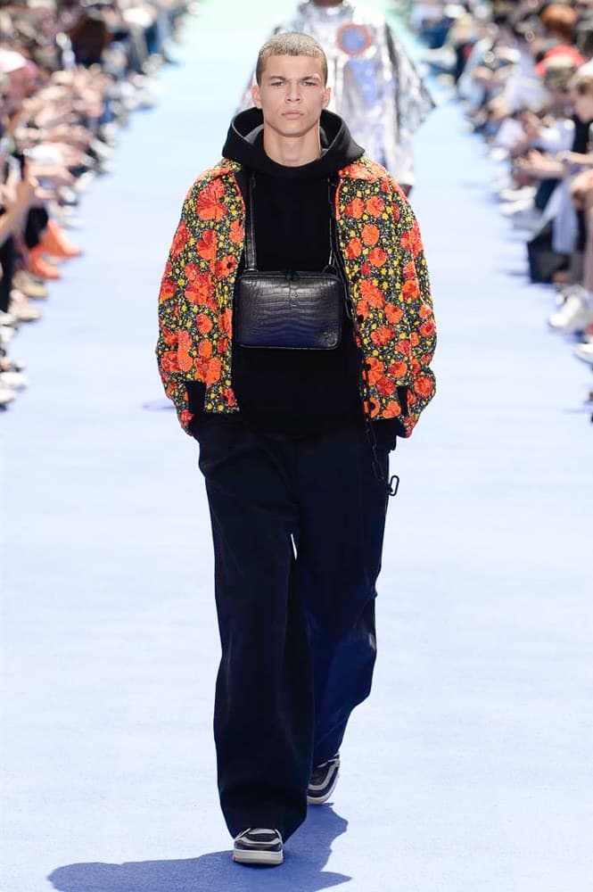 ヴァージル・アブローが手がけた Louis Vuitton 2019年春夏コレクションが遂にお披露目 ファッション界に後世まで語り継がれる歴史的1ページが追加される 〈Louis Vuitton（ルイ ヴィトン）〉がVirgil Abloh（ヴァージル・アブロー）のアーティスティック・ディレクター就任を発表してから早3ヶ月、遂に今をときめくデザイナーの〈LV〉デビューとなる2019年春夏コレクションがお披露目を迎えた。  晴天のパレ・ロワイヤル庭園には、Kanye West（カニエ・ウェスト）とその妻Kim Kardashian（キム・カーダシアン）や、Rihanna（リアーナ）、Kylie Jenner（カイリー・ジェンナー）、A$AP Rocky（エイサップ・ロッキー）、村上隆など、Virgilの友人でもある豪華ゲストが集結。ヒップホップとジャズを繋ぐ成長著しいカルテット、BadBadNotGood（バッドバッドノットグッド）がサウンドトラックを提供したランウェイには、Kid Cudi（キッド・カディ）、Dev Hynes（デヴ・ハインズ）、A$AP Nast（エイサップ・ナスト）、Playboi Carti（プレイボーイ・カルティ）、Theophilus London（テオフィルス・ロンドン）、そして〈Palace（パレス）〉よりLucien Clarke（ルシアン・クラーク）とBlondey McCoy（ブロンディ・マッコイ）らがモデルに起用された。  全56体のルックでは、〈Off-White™️（オフホワイト）〉の党首の真髄である“ラグジュアリーとストリートの融合”が力強さとともに解き放たれた。タイダイ、フローラルパターン、来年80周年を迎える映画『オズの魔法使い』とのコラボレーションなど、必要最小限でありながらも視覚的魅力を放つアイテムがコレクションにエンターテイメント性を付与し、ドラマチックな雰囲気を醸すそのランウェイでは、ルーズフィットのパンツやユーティリティベスト、シアーシャツ、フーディ、仕立ての良いトレンチコートなどがカラーパレットごとに紹介されていく。また、昨日Virgil本人が先行公開したバスケットシューズ風の一足を含め、フットウェアはハイトップシルエットを中心に構成され、上質なドレスシューズもシューレースの配色で遊びをプラス。加えて、〈Louis Vuitton〉の象徴とも言えるラゲージ類は、モノグラムをエンボス加工した半透明の素材やチェーンの斬新な組み合わせにより、良い意味でモードの品格を削ぎ落とした仕上がりにより、観衆の目を釘付けにした。  大喝采の中で迎えたフィナーレではVirgilが涙を流しながら花道を歩き抜け、自身の師匠であるKanyeと熱い抱擁を交わすシーンも。そんな〈Louis Vuitton〉、そしてVirgilの歴史的一幕を是非、上のフォトギャラリーからチェックしてみてはいかがだろうか。