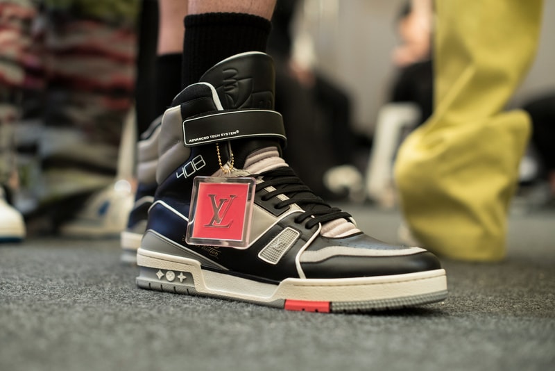 ヴァージル・アブローのビジョンを体現した Louis Vuitton 2019年春夏コレクションのバックステージに潜入 ランウェイルックからは確認することのできない各種アパレル&アクセサリーのディテールを撮影することに成功した服好き必見のフォトセット Virgil Abloh(ヴァージル・アブロー)は、〈Louis Vuitton(ルイ ヴィトン)〉のアーティスティックデザイナー就任後初のランウェイをパリのパレ・ロワイヤル庭園で披露した。歴史的一幕で、今をときめくイリノイ州出身のデザイナーは〈LV〉に未だかつて見たことのない景色を見せたと言っても過言ではないだろう。だが、そのクリエイションの真髄は、バックステージでこそ痛感するものだった。 ベストやポロシャツなどに見られる3Dのジオメトリックパターンで立体感を演出したレイヤード、モノグラムの花型のカフスボタン、大胆な原色使いなど、Virgilは〈Louis Vuitton〉のDNAを従来とは異なるアプローチで体現。また、セーター、スーツ、フーディといったメンズウェアも前衛的なカッティングとステッチワークで新鮮味が付与されると同時に、組み込み式のポーチやジッパー、プルタブなどを応用することで、壮麗なデザインの中にカジュアル/アウトドアウェアに着想を得た機能性を追加している。その一方で、ハイカットシルエットを中心に構成されたスニーカーは、Air Jordanや〈Ewing Athletics(ユーイング アスレチックス)〉などのバスケットシューズを原型に、今後の展開に自然と期待が膨らむデザインのものが数多く出揃った印象だ。そして、言及せずには終われないアクセサリーコレクションだが、ラゲージについてはまさに“型破り”という言葉がよく似合う。Kim Jones(キム・ジョーンズ)政権の頃から変革が見え隠れしたが、建築デザインを背景に持つVirgilが加わったことで、クラシカルなシルエットは全く別物のような表情へと生まれ変わっている。 ランウェイルックからは確認することのできない各プロダクトのディテールワークを是非、上のフォトギャラリーからチェックしてみてほしい。あわせて、本ランウェイのハイライトとも言えるVirgilとKanye West(カニエ・ウェスト)が涙ながらに抱擁しあう感動の1シーンもお見逃しなく。