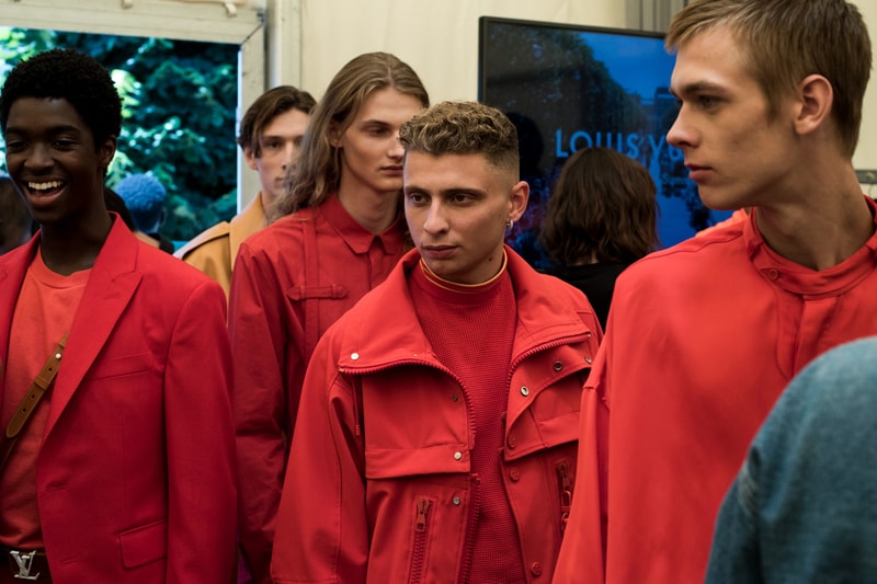 ヴァージル・アブローのビジョンを体現した Louis Vuitton 2019年春夏コレクションのバックステージに潜入 ランウェイルックからは確認することのできない各種アパレル&アクセサリーのディテールを撮影することに成功した服好き必見のフォトセット Virgil Abloh(ヴァージル・アブロー)は、〈Louis Vuitton(ルイ ヴィトン)〉のアーティスティックデザイナー就任後初のランウェイをパリのパレ・ロワイヤル庭園で披露した。歴史的一幕で、今をときめくイリノイ州出身のデザイナーは〈LV〉に未だかつて見たことのない景色を見せたと言っても過言ではないだろう。だが、そのクリエイションの真髄は、バックステージでこそ痛感するものだった。 ベストやポロシャツなどに見られる3Dのジオメトリックパターンで立体感を演出したレイヤード、モノグラムの花型のカフスボタン、大胆な原色使いなど、Virgilは〈Louis Vuitton〉のDNAを従来とは異なるアプローチで体現。また、セーター、スーツ、フーディといったメンズウェアも前衛的なカッティングとステッチワークで新鮮味が付与されると同時に、組み込み式のポーチやジッパー、プルタブなどを応用することで、壮麗なデザインの中にカジュアル/アウトドアウェアに着想を得た機能性を追加している。その一方で、ハイカットシルエットを中心に構成されたスニーカーは、Air Jordanや〈Ewing Athletics(ユーイング アスレチックス)〉などのバスケットシューズを原型に、今後の展開に自然と期待が膨らむデザインのものが数多く出揃った印象だ。そして、言及せずには終われないアクセサリーコレクションだが、ラゲージについてはまさに“型破り”という言葉がよく似合う。Kim Jones(キム・ジョーンズ)政権の頃から変革が見え隠れしたが、建築デザインを背景に持つVirgilが加わったことで、クラシカルなシルエットは全く別物のような表情へと生まれ変わっている。 ランウェイルックからは確認することのできない各プロダクトのディテールワークを是非、上のフォトギャラリーからチェックしてみてほしい。あわせて、本ランウェイのハイライトとも言えるVirgilとKanye West(カニエ・ウェスト)が涙ながらに抱擁しあう感動の1シーンもお見逃しなく。