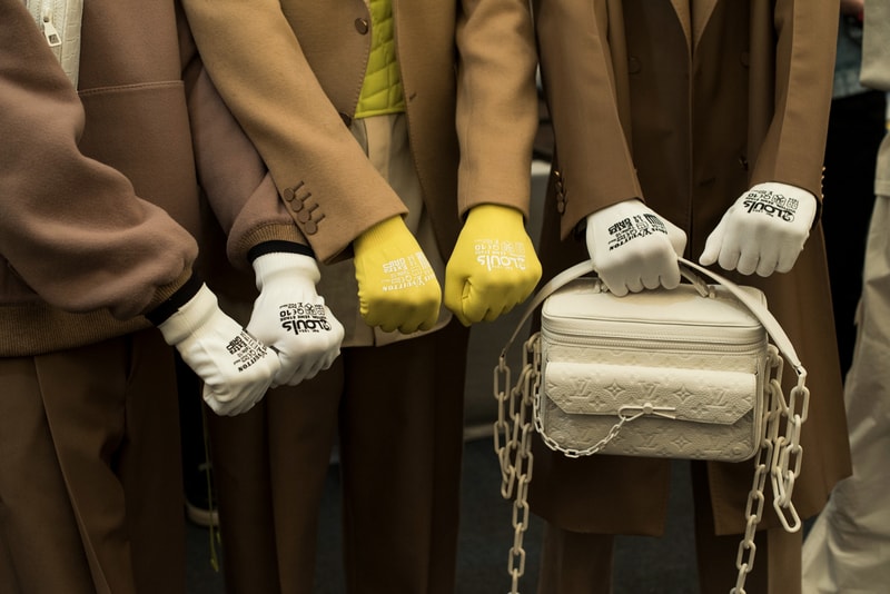 ヴァージル・アブローのビジョンを体現した Louis Vuitton 2019年春夏コレクションのバックステージに潜入 ランウェイルックからは確認することのできない各種アパレル&アクセサリーのディテールを撮影することに成功した服好き必見のフォトセット Virgil Abloh(ヴァージル・アブロー)は、〈Louis Vuitton(ルイ ヴィトン)〉のアーティスティックデザイナー就任後初のランウェイをパリのパレ・ロワイヤル庭園で披露した。歴史的一幕で、今をときめくイリノイ州出身のデザイナーは〈LV〉に未だかつて見たことのない景色を見せたと言っても過言ではないだろう。だが、そのクリエイションの真髄は、バックステージでこそ痛感するものだった。 ベストやポロシャツなどに見られる3Dのジオメトリックパターンで立体感を演出したレイヤード、モノグラムの花型のカフスボタン、大胆な原色使いなど、Virgilは〈Louis Vuitton〉のDNAを従来とは異なるアプローチで体現。また、セーター、スーツ、フーディといったメンズウェアも前衛的なカッティングとステッチワークで新鮮味が付与されると同時に、組み込み式のポーチやジッパー、プルタブなどを応用することで、壮麗なデザインの中にカジュアル/アウトドアウェアに着想を得た機能性を追加している。その一方で、ハイカットシルエットを中心に構成されたスニーカーは、Air Jordanや〈Ewing Athletics(ユーイング アスレチックス)〉などのバスケットシューズを原型に、今後の展開に自然と期待が膨らむデザインのものが数多く出揃った印象だ。そして、言及せずには終われないアクセサリーコレクションだが、ラゲージについてはまさに“型破り”という言葉がよく似合う。Kim Jones(キム・ジョーンズ)政権の頃から変革が見え隠れしたが、建築デザインを背景に持つVirgilが加わったことで、クラシカルなシルエットは全く別物のような表情へと生まれ変わっている。 ランウェイルックからは確認することのできない各プロダクトのディテールワークを是非、上のフォトギャラリーからチェックしてみてほしい。あわせて、本ランウェイのハイライトとも言えるVirgilとKanye West(カニエ・ウェスト)が涙ながらに抱擁しあう感動の1シーンもお見逃しなく。