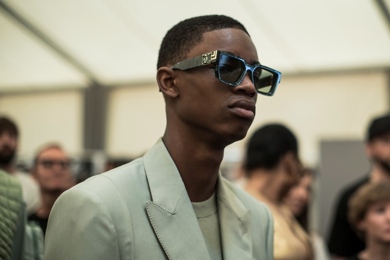 ヴァージル・アブローのビジョンを体現した Louis Vuitton 2019年春夏コレクションのバックステージに潜入 ランウェイルックからは確認することのできない各種アパレル&アクセサリーのディテールを撮影することに成功した服好き必見のフォトセット Virgil Abloh(ヴァージル・アブロー)は、〈Louis Vuitton(ルイ ヴィトン)〉のアーティスティックデザイナー就任後初のランウェイをパリのパレ・ロワイヤル庭園で披露した。歴史的一幕で、今をときめくイリノイ州出身のデザイナーは〈LV〉に未だかつて見たことのない景色を見せたと言っても過言ではないだろう。だが、そのクリエイションの真髄は、バックステージでこそ痛感するものだった。 ベストやポロシャツなどに見られる3Dのジオメトリックパターンで立体感を演出したレイヤード、モノグラムの花型のカフスボタン、大胆な原色使いなど、Virgilは〈Louis Vuitton〉のDNAを従来とは異なるアプローチで体現。また、セーター、スーツ、フーディといったメンズウェアも前衛的なカッティングとステッチワークで新鮮味が付与されると同時に、組み込み式のポーチやジッパー、プルタブなどを応用することで、壮麗なデザインの中にカジュアル/アウトドアウェアに着想を得た機能性を追加している。その一方で、ハイカットシルエットを中心に構成されたスニーカーは、Air Jordanや〈Ewing Athletics(ユーイング アスレチックス)〉などのバスケットシューズを原型に、今後の展開に自然と期待が膨らむデザインのものが数多く出揃った印象だ。そして、言及せずには終われないアクセサリーコレクションだが、ラゲージについてはまさに“型破り”という言葉がよく似合う。Kim Jones(キム・ジョーンズ)政権の頃から変革が見え隠れしたが、建築デザインを背景に持つVirgilが加わったことで、クラシカルなシルエットは全く別物のような表情へと生まれ変わっている。 ランウェイルックからは確認することのできない各プロダクトのディテールワークを是非、上のフォトギャラリーからチェックしてみてほしい。あわせて、本ランウェイのハイライトとも言えるVirgilとKanye West(カニエ・ウェスト)が涙ながらに抱擁しあう感動の1シーンもお見逃しなく。