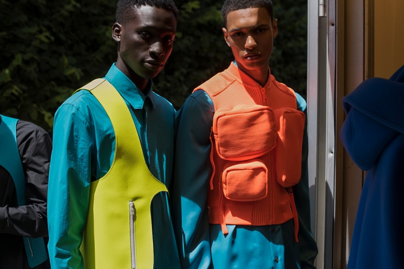 ヴァージル・アブローのビジョンを体現した Louis Vuitton 2019年春夏コレクションのバックステージに潜入 ランウェイルックからは確認することのできない各種アパレル&アクセサリーのディテールを撮影することに成功した服好き必見のフォトセット Virgil Abloh(ヴァージル・アブロー)は、〈Louis Vuitton(ルイ ヴィトン)〉のアーティスティックデザイナー就任後初のランウェイをパリのパレ・ロワイヤル庭園で披露した。歴史的一幕で、今をときめくイリノイ州出身のデザイナーは〈LV〉に未だかつて見たことのない景色を見せたと言っても過言ではないだろう。だが、そのクリエイションの真髄は、バックステージでこそ痛感するものだった。 ベストやポロシャツなどに見られる3Dのジオメトリックパターンで立体感を演出したレイヤード、モノグラムの花型のカフスボタン、大胆な原色使いなど、Virgilは〈Louis Vuitton〉のDNAを従来とは異なるアプローチで体現。また、セーター、スーツ、フーディといったメンズウェアも前衛的なカッティングとステッチワークで新鮮味が付与されると同時に、組み込み式のポーチやジッパー、プルタブなどを応用することで、壮麗なデザインの中にカジュアル/アウトドアウェアに着想を得た機能性を追加している。その一方で、ハイカットシルエットを中心に構成されたスニーカーは、Air Jordanや〈Ewing Athletics(ユーイング アスレチックス)〉などのバスケットシューズを原型に、今後の展開に自然と期待が膨らむデザインのものが数多く出揃った印象だ。そして、言及せずには終われないアクセサリーコレクションだが、ラゲージについてはまさに“型破り”という言葉がよく似合う。Kim Jones(キム・ジョーンズ)政権の頃から変革が見え隠れしたが、建築デザインを背景に持つVirgilが加わったことで、クラシカルなシルエットは全く別物のような表情へと生まれ変わっている。 ランウェイルックからは確認することのできない各プロダクトのディテールワークを是非、上のフォトギャラリーからチェックしてみてほしい。あわせて、本ランウェイのハイライトとも言えるVirgilとKanye West(カニエ・ウェスト)が涙ながらに抱擁しあう感動の1シーンもお見逃しなく。