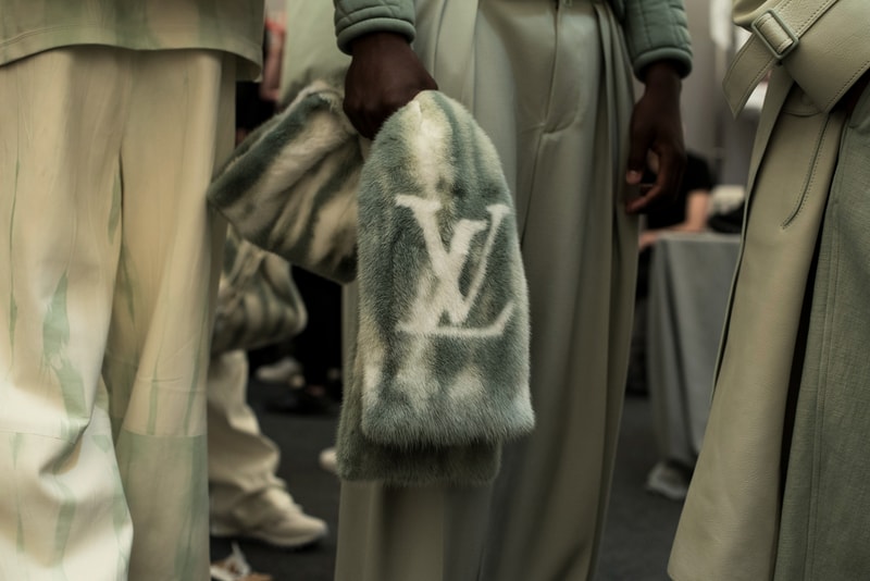 ヴァージル・アブローのビジョンを体現した Louis Vuitton 2019年春夏コレクションのバックステージに潜入 ランウェイルックからは確認することのできない各種アパレル&アクセサリーのディテールを撮影することに成功した服好き必見のフォトセット Virgil Abloh(ヴァージル・アブロー)は、〈Louis Vuitton(ルイ ヴィトン)〉のアーティスティックデザイナー就任後初のランウェイをパリのパレ・ロワイヤル庭園で披露した。歴史的一幕で、今をときめくイリノイ州出身のデザイナーは〈LV〉に未だかつて見たことのない景色を見せたと言っても過言ではないだろう。だが、そのクリエイションの真髄は、バックステージでこそ痛感するものだった。 ベストやポロシャツなどに見られる3Dのジオメトリックパターンで立体感を演出したレイヤード、モノグラムの花型のカフスボタン、大胆な原色使いなど、Virgilは〈Louis Vuitton〉のDNAを従来とは異なるアプローチで体現。また、セーター、スーツ、フーディといったメンズウェアも前衛的なカッティングとステッチワークで新鮮味が付与されると同時に、組み込み式のポーチやジッパー、プルタブなどを応用することで、壮麗なデザインの中にカジュアル/アウトドアウェアに着想を得た機能性を追加している。その一方で、ハイカットシルエットを中心に構成されたスニーカーは、Air Jordanや〈Ewing Athletics(ユーイング アスレチックス)〉などのバスケットシューズを原型に、今後の展開に自然と期待が膨らむデザインのものが数多く出揃った印象だ。そして、言及せずには終われないアクセサリーコレクションだが、ラゲージについてはまさに“型破り”という言葉がよく似合う。Kim Jones(キム・ジョーンズ)政権の頃から変革が見え隠れしたが、建築デザインを背景に持つVirgilが加わったことで、クラシカルなシルエットは全く別物のような表情へと生まれ変わっている。 ランウェイルックからは確認することのできない各プロダクトのディテールワークを是非、上のフォトギャラリーからチェックしてみてほしい。あわせて、本ランウェイのハイライトとも言えるVirgilとKanye West(カニエ・ウェスト)が涙ながらに抱擁しあう感動の1シーンもお見逃しなく。