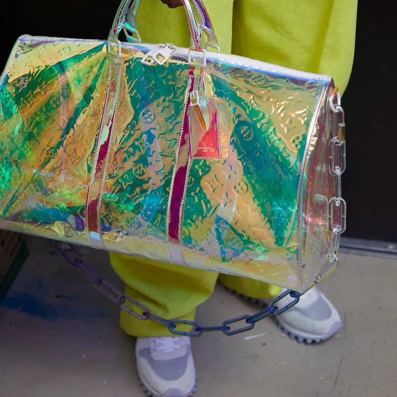 Louis Vuitton がヴァージル・アブローの初コレクションの一部を先行公開 〈LV〉史上、未だかつて類を見ない斬新なアイテムはどのような世界観の中でお披露目されることになるのだろうか…… 〈Off-White™️（オフホワイト）〉の2019年春夏コレクション発表を終えたVirgil Abloh（ヴァージル・アブロー）は休む間もなく、今度は〈Louis Vuitton（ルイ ヴィトン）〉のメンズデザイナー就任後初のコレクション発表に向けて奔走していることだろう。  だが、〈LV〉は6月21日14時半（現地時間）のランウェイに先駆けて、ブランドの公式Instagramでお披露目されるアイテムの一部を先行公開。@louisvuittonに投稿された写真の中でも特に印象的なものは、半透明の素材に〈LV〉のモノグラムをエンボス加工したキーポルなどのラゲージ。また、その他のバッグ類も独特なチェーン使いで過去に類を見ない斬新な仕上がりとなっているほか、アパレル各種も鮮やかな単色やタイダイを採用しており、明日のショーではファッション界の権威の新たな一面を見ることになることが予想される。  あわせて、Virgilが公開した〈Louis Vuitton〉の新作スニーカーのデザインもお見逃しのないように。