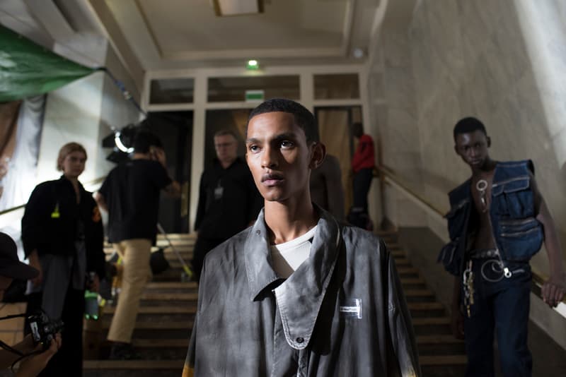 Off-White™ 2019年春夏コレクションのバックステージに潜入 〈Nike〉とのコラボレーション継続を確約する初見のAir Max 97も確認 Virgil Abloh(ヴァージル・アブロー)がパリファッションウィーク期間中に発表した〈Off-White™(オフホワイト)〉の2019年春夏コレクションは、1980〜90年代のアメリカのユースカルチャーを現代的に解釈すると同時に、Futura(フューチュラ)などにも多大な影響を与えたイーストブルックリンの伝説のグラフィティーライター、Dondi White(ドンディ・ホワイト)にトリビュートを捧げるものだった。 『HYPEBEAST』はこの文化的背景を感じさせるランウェイの舞台裏に潜入。コレクションでは“DONDI”の名を配したTシャツのほか、“Style Master”の異名を持つ彼の作風にオマージュを捧げるグラフィティを随所で確認。また、コレクションの中核をなすデニムピースもスカルモチーフやウィットに富んだリング使い、ダメージ/ペイント加工など、細部にまで一切の抜かりがなく、『ザ・シンプソンズ』のバートがフロントを飾るニットやTシャツはまさに90’sの象徴のひとつであるキャラクターものの最たる例だろう。 一方で、〈Nike(ナイキ)〉とのコラボレーションからも初見のスニーカーがベールを脱いだ。ベースに採用したのは、Air Max 97。グレーのアッパーはシームレスな仕上がりで、サイドにはグラデーションのスウッシュをセットしたものも。どのタイミングでのリリースになるのかは〈Nike〉からのアップデートを待つ必要がありそうだが、両者の関係はまだまだ継続路線と見ていいだろう。 〈Off-White™〉の2019年春夏コレクションの全貌を解明するバックステージフォトは、上のフォトギャラリーから。あわせて、同コレクションのランウェイルックもお見逃しなく。