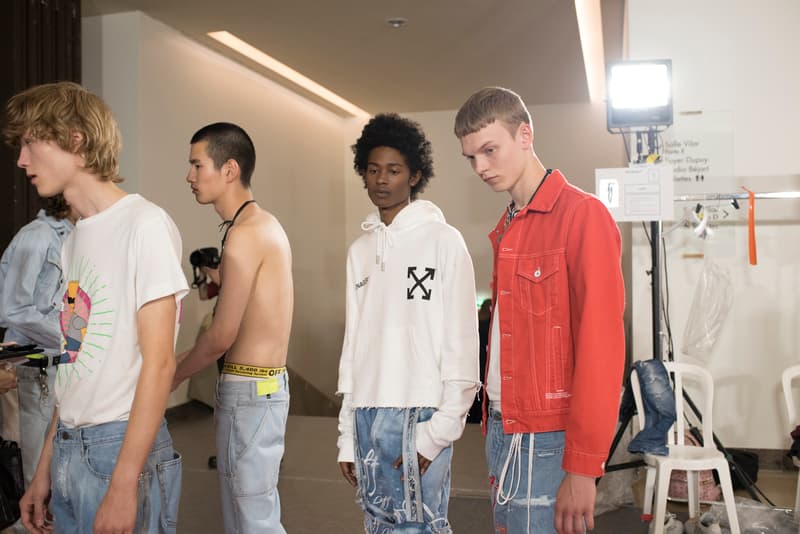 Off-White™ 2019年春夏コレクションのバックステージに潜入 〈Nike〉とのコラボレーション継続を確約する初見のAir Max 97も確認 Virgil Abloh(ヴァージル・アブロー)がパリファッションウィーク期間中に発表した〈Off-White™(オフホワイト)〉の2019年春夏コレクションは、1980〜90年代のアメリカのユースカルチャーを現代的に解釈すると同時に、Futura(フューチュラ)などにも多大な影響を与えたイーストブルックリンの伝説のグラフィティーライター、Dondi White(ドンディ・ホワイト)にトリビュートを捧げるものだった。 『HYPEBEAST』はこの文化的背景を感じさせるランウェイの舞台裏に潜入。コレクションでは“DONDI”の名を配したTシャツのほか、“Style Master”の異名を持つ彼の作風にオマージュを捧げるグラフィティを随所で確認。また、コレクションの中核をなすデニムピースもスカルモチーフやウィットに富んだリング使い、ダメージ/ペイント加工など、細部にまで一切の抜かりがなく、『ザ・シンプソンズ』のバートがフロントを飾るニットやTシャツはまさに90’sの象徴のひとつであるキャラクターものの最たる例だろう。 一方で、〈Nike(ナイキ)〉とのコラボレーションからも初見のスニーカーがベールを脱いだ。ベースに採用したのは、Air Max 97。グレーのアッパーはシームレスな仕上がりで、サイドにはグラデーションのスウッシュをセットしたものも。どのタイミングでのリリースになるのかは〈Nike〉からのアップデートを待つ必要がありそうだが、両者の関係はまだまだ継続路線と見ていいだろう。 〈Off-White™〉の2019年春夏コレクションの全貌を解明するバックステージフォトは、上のフォトギャラリーから。あわせて、同コレクションのランウェイルックもお見逃しなく。