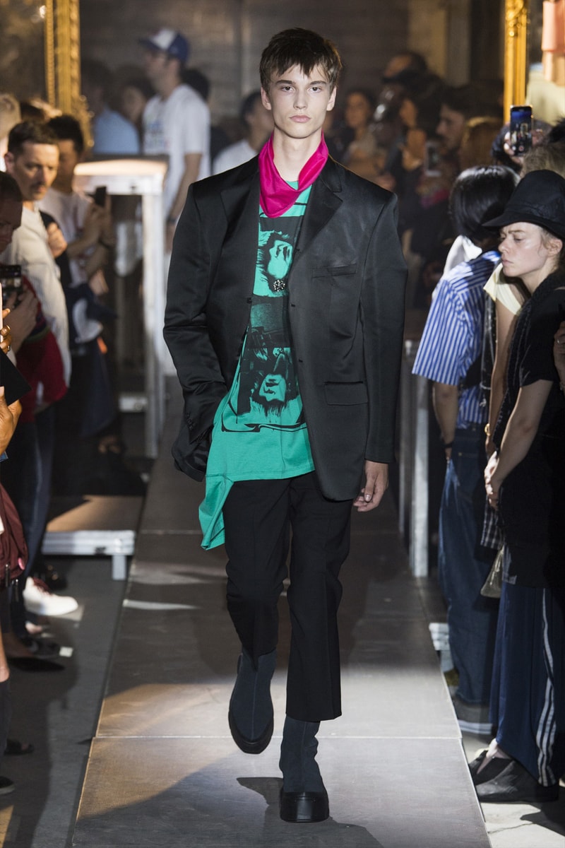 ファッション界に新たな波の到来を予感させる Raf Simons 2019年春夏コレクション ストリートとプリントもの一辺倒の現代シーンに天才デザイナーが待ったをかける Raf Simons（ラフ・シモンズ）が2019年春夏コレクションを発表するべく、再びパリファッションウィークへと舞い戻ってきた。舞台は、パリ郊外の都市モントルイユに佇むレイブ感が充満したとある倉庫。ベルギーが産んだ天才デザイナーはこの地で、スポーツカジュアル一辺倒になった現代に一石を投じるべく、ラグジュアリーシーンにおけるテーラードの復権を高らかに宣言した。  Rafは『Vogue』のインタビューの中で、「我々には新たなアウトラインが必要である。私は私自身もその一部であったことを理解した上で申し上げるが、プリント入りのフーディがあまりにも多すぎる！皆も気づいているだろう、移行するための何かが必要なんだ」と、ストリートに右へならえとなったファッション界で自らが新たなルールを作るという強い意志を表明。その結果に、〈Raf Simons〉の最新コレクションは、エメラルド、ベイビーブルー、ゴールド、ピンクパープルといった高級感漂うサテン素材を多用し、1970〜80年代のニューウェーブを表現している。しかし、その中でも斬新なシルエットとカッティングを応用したニットウェアや、スカーフ、The Clash（ザ・クラッシュ）のコンサートフォトをプリントしたユースカルチャーへオマージュを捧げるもの、安全ピンやスタッズといったパンクなアクセサリーなど、Rafが得意とするタッチも随所に織り込まれていた。  新時代の指標となる可能性を秘めた〈Raf Simons〉の2019年春夏コレクションのランウェイルックは、上のフォトギャラリーから。また、同じくパリで発表されたVirgil Abloh（ヴァージル・アブロー）の〈Louis Vuitton（ルイ ヴィトン）〉デビューコレクションもお見逃しなく。