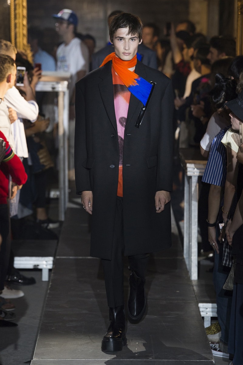 ファッション界に新たな波の到来を予感させる Raf Simons 2019年春夏コレクション ストリートとプリントもの一辺倒の現代シーンに天才デザイナーが待ったをかける Raf Simons（ラフ・シモンズ）が2019年春夏コレクションを発表するべく、再びパリファッションウィークへと舞い戻ってきた。舞台は、パリ郊外の都市モントルイユに佇むレイブ感が充満したとある倉庫。ベルギーが産んだ天才デザイナーはこの地で、スポーツカジュアル一辺倒になった現代に一石を投じるべく、ラグジュアリーシーンにおけるテーラードの復権を高らかに宣言した。  Rafは『Vogue』のインタビューの中で、「我々には新たなアウトラインが必要である。私は私自身もその一部であったことを理解した上で申し上げるが、プリント入りのフーディがあまりにも多すぎる！皆も気づいているだろう、移行するための何かが必要なんだ」と、ストリートに右へならえとなったファッション界で自らが新たなルールを作るという強い意志を表明。その結果に、〈Raf Simons〉の最新コレクションは、エメラルド、ベイビーブルー、ゴールド、ピンクパープルといった高級感漂うサテン素材を多用し、1970〜80年代のニューウェーブを表現している。しかし、その中でも斬新なシルエットとカッティングを応用したニットウェアや、スカーフ、The Clash（ザ・クラッシュ）のコンサートフォトをプリントしたユースカルチャーへオマージュを捧げるもの、安全ピンやスタッズといったパンクなアクセサリーなど、Rafが得意とするタッチも随所に織り込まれていた。  新時代の指標となる可能性を秘めた〈Raf Simons〉の2019年春夏コレクションのランウェイルックは、上のフォトギャラリーから。また、同じくパリで発表されたVirgil Abloh（ヴァージル・アブロー）の〈Louis Vuitton（ルイ ヴィトン）〉デビューコレクションもお見逃しなく。