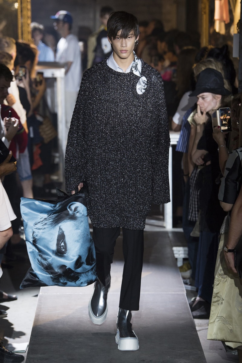ファッション界に新たな波の到来を予感させる Raf Simons 2019年春夏コレクション ストリートとプリントもの一辺倒の現代シーンに天才デザイナーが待ったをかける Raf Simons（ラフ・シモンズ）が2019年春夏コレクションを発表するべく、再びパリファッションウィークへと舞い戻ってきた。舞台は、パリ郊外の都市モントルイユに佇むレイブ感が充満したとある倉庫。ベルギーが産んだ天才デザイナーはこの地で、スポーツカジュアル一辺倒になった現代に一石を投じるべく、ラグジュアリーシーンにおけるテーラードの復権を高らかに宣言した。  Rafは『Vogue』のインタビューの中で、「我々には新たなアウトラインが必要である。私は私自身もその一部であったことを理解した上で申し上げるが、プリント入りのフーディがあまりにも多すぎる！皆も気づいているだろう、移行するための何かが必要なんだ」と、ストリートに右へならえとなったファッション界で自らが新たなルールを作るという強い意志を表明。その結果に、〈Raf Simons〉の最新コレクションは、エメラルド、ベイビーブルー、ゴールド、ピンクパープルといった高級感漂うサテン素材を多用し、1970〜80年代のニューウェーブを表現している。しかし、その中でも斬新なシルエットとカッティングを応用したニットウェアや、スカーフ、The Clash（ザ・クラッシュ）のコンサートフォトをプリントしたユースカルチャーへオマージュを捧げるもの、安全ピンやスタッズといったパンクなアクセサリーなど、Rafが得意とするタッチも随所に織り込まれていた。  新時代の指標となる可能性を秘めた〈Raf Simons〉の2019年春夏コレクションのランウェイルックは、上のフォトギャラリーから。また、同じくパリで発表されたVirgil Abloh（ヴァージル・アブロー）の〈Louis Vuitton（ルイ ヴィトン）〉デビューコレクションもお見逃しなく。