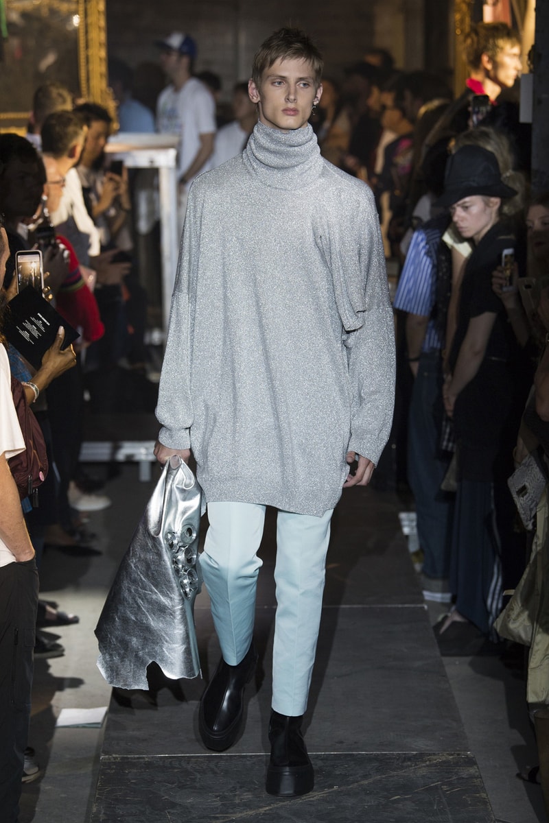 ファッション界に新たな波の到来を予感させる Raf Simons 2019年春夏コレクション ストリートとプリントもの一辺倒の現代シーンに天才デザイナーが待ったをかける Raf Simons（ラフ・シモンズ）が2019年春夏コレクションを発表するべく、再びパリファッションウィークへと舞い戻ってきた。舞台は、パリ郊外の都市モントルイユに佇むレイブ感が充満したとある倉庫。ベルギーが産んだ天才デザイナーはこの地で、スポーツカジュアル一辺倒になった現代に一石を投じるべく、ラグジュアリーシーンにおけるテーラードの復権を高らかに宣言した。  Rafは『Vogue』のインタビューの中で、「我々には新たなアウトラインが必要である。私は私自身もその一部であったことを理解した上で申し上げるが、プリント入りのフーディがあまりにも多すぎる！皆も気づいているだろう、移行するための何かが必要なんだ」と、ストリートに右へならえとなったファッション界で自らが新たなルールを作るという強い意志を表明。その結果に、〈Raf Simons〉の最新コレクションは、エメラルド、ベイビーブルー、ゴールド、ピンクパープルといった高級感漂うサテン素材を多用し、1970〜80年代のニューウェーブを表現している。しかし、その中でも斬新なシルエットとカッティングを応用したニットウェアや、スカーフ、The Clash（ザ・クラッシュ）のコンサートフォトをプリントしたユースカルチャーへオマージュを捧げるもの、安全ピンやスタッズといったパンクなアクセサリーなど、Rafが得意とするタッチも随所に織り込まれていた。  新時代の指標となる可能性を秘めた〈Raf Simons〉の2019年春夏コレクションのランウェイルックは、上のフォトギャラリーから。また、同じくパリで発表されたVirgil Abloh（ヴァージル・アブロー）の〈Louis Vuitton（ルイ ヴィトン）〉デビューコレクションもお見逃しなく。