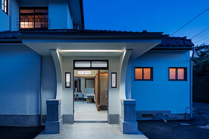 築80年を超える典型的な日本家屋を改修した鎌倉のオフィス兼住宅 非の打ち所のない和室や壁、天井の味わいを活かし、地面から60cm上がっている床の在り方に注目した「スキーマ建築計画」の匠な仕事 町を考えつつ、家具から建築までデザインする長坂常主宰の「スキーマ建築計画」が、鎌倉の緑豊かで閑静な住宅街の中にオフィス兼住宅を計画した。築80年を超える典型的な日本家屋を改修した『北条SANCI』は、壁、天井の味わいを活かすと同時に、性格分けをしたゾーニングを考慮する上で、地面から60cm上がった床の在り方に着目したという。西側には縁側を介して庭と繋がった非の打ち所のない和室、北東側には多様なレベル差のある板の間にキッチンを配置した共用空間があり、その間に特に特徴的な空間要素である玄関をそのまま中央まで拡張させた土間部分が存在。ひとつ基盤となる畳をベースにそれぞれの広さと素材、設置する家具を操作することで、上下左右多様な目線を生み、どこにいてもいつでも豊かな自然と活気を感じられる場を生み出すと同時に、その操作によって生まれた多様過ぎる表情を少しコントロールするべく、ところどころで無機質なグレイの家具を挿入している。   緩やかに繰り返される有機質と無機質の一定のコントラストが全体の表情をつなぎとめ、空間の多様性さをコントロールした「スキーマ建築計画」の匠な仕事の全貌を是非、上のフォトギャラリーから覗いてみてほしい。  「Toy’s Factory（トイズ ファクトリー）」の新社屋やロンドンで開催された『MR PORTER（ミスター ポーター）』x『BEAMS（ビームス）』の限定プログラムなど、「スキーマ建築計画」のその他のプロジェクトもあわせてご確認を。