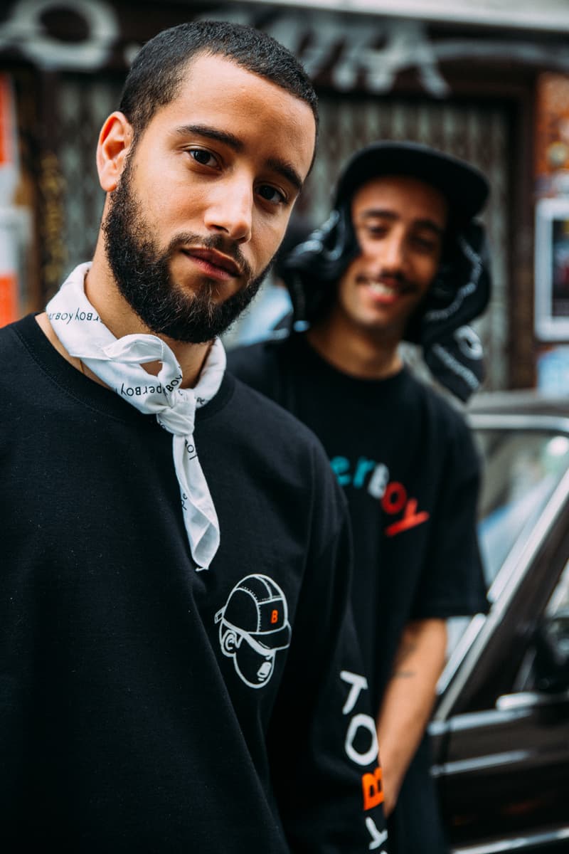 BEAMS がパリの人気カフェ PAPERBOY とのコラボカプセルを逆輸入 〈Nike〉や〈Vans〉も信頼を置く『PAPERBOY』と『BEAMS』のパリ限定アイテムが急遽国内でもリリースされることに 『PAPERBOY(ペーパーボーイ)』、読者の中では知っている人の方が少ないかもしれない。2014年にパリの11区にオープンした『PAPERBOY』はオーガニックの野菜を使用したサンドウィッチを看板メニューに掲げ、〈Vans(ヴァンズ)〉や〈Nike(ナイキ)〉にもケータリングを依頼されるなど、ファッションシーンとも非常に密接な関係にあるパリの最注目カフェのひとつである。 『BEAMS(ビームス)』は先日、この『PAPERBOY』でポップアップを開催。ここでは全9型で構成されるコラボカプセルをリリースし、イベントは大盛況の中、幕を閉じた。だが、逆輸入形式でこのダブルネームの国内販売が決定。『PAPERBOY』のサンドウィッチを彷彿とさせるカラフルな配色や“B”ロゴのキャップをかぶるショップアイコンをプリントしたTシャツやフーディに加え、日本限定仕様のマグカップとキーホルダーも同時展開されるという。 発売日は7月14日(土)で、取り扱いは『ビームス 原宿』と公式オンラインショップのみとのこと。リリースに備えて、上のルックブックから気になるアイテムをピックアップしておこう。 また、『BEAMS T』と祐天寺のカルチャーハブ『Guru’s Cut&Stand(グルズ カット&スタンド)』の各種コラボアイテムもお買い逃しのないように。