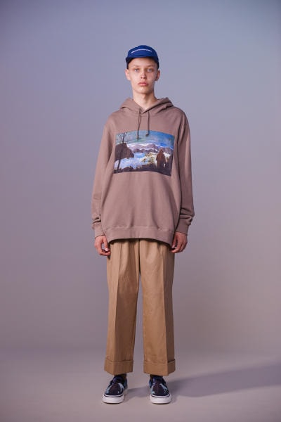 美しい山岳風景とカレッジスタイルが同居する John UNDERCOVER 2019年春夏コレクション 〈Polo ○alph Lauren〉にもオマージュを捧げる本ラインでは表現できない高橋盾の今の気分 デザイナー高橋盾が2013年秋冬シーズンに立ち上げたセカンドライン〈John UNDERCOVER（ジョン アンダーカバー）〉の2019年春夏コレクションは、本ブランドが得意とするグラフィック性の高さを改めて印象づけるものとなった。  主役はロングコートやレインコート、フーディなど、全面に美しい山岳が描かれたインパクトのあるグラフィカルなアパレルたち。しかしその一方で、今こそ一周回って気になるプレッピーやスクールの要素も現代的に解釈されており、カレッジロゴを取り入れたフード付きシャツやレタードカーディガン、ブレザーなどがコレクション全体にアクセントを追加している。  立ち上げはまだしばらく先にはなるが、ひとまず上のフォトギャラリーからルックブックに目を通してみてはいかがだろうか。  〈STÜSSY（ステューシー）〉のBob Marley（ボブ・マーリー）を称えた最新コレクションや、〈Noah（ノア）〉とKevin Cummins（ケビン・カミンズ）のコラボコレクションなど、『HYPEBEAST』がお届けするその他の最旬ファッションニュースもあわせてご確認を。