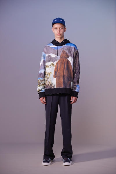 美しい山岳風景とカレッジスタイルが同居する John UNDERCOVER 2019年春夏コレクション 〈Polo ○alph Lauren〉にもオマージュを捧げる本ラインでは表現できない高橋盾の今の気分 デザイナー高橋盾が2013年秋冬シーズンに立ち上げたセカンドライン〈John UNDERCOVER（ジョン アンダーカバー）〉の2019年春夏コレクションは、本ブランドが得意とするグラフィック性の高さを改めて印象づけるものとなった。  主役はロングコートやレインコート、フーディなど、全面に美しい山岳が描かれたインパクトのあるグラフィカルなアパレルたち。しかしその一方で、今こそ一周回って気になるプレッピーやスクールの要素も現代的に解釈されており、カレッジロゴを取り入れたフード付きシャツやレタードカーディガン、ブレザーなどがコレクション全体にアクセントを追加している。  立ち上げはまだしばらく先にはなるが、ひとまず上のフォトギャラリーからルックブックに目を通してみてはいかがだろうか。  〈STÜSSY（ステューシー）〉のBob Marley（ボブ・マーリー）を称えた最新コレクションや、〈Noah（ノア）〉とKevin Cummins（ケビン・カミンズ）のコラボコレクションなど、『HYPEBEAST』がお届けするその他の最旬ファッションニュースもあわせてご確認を。