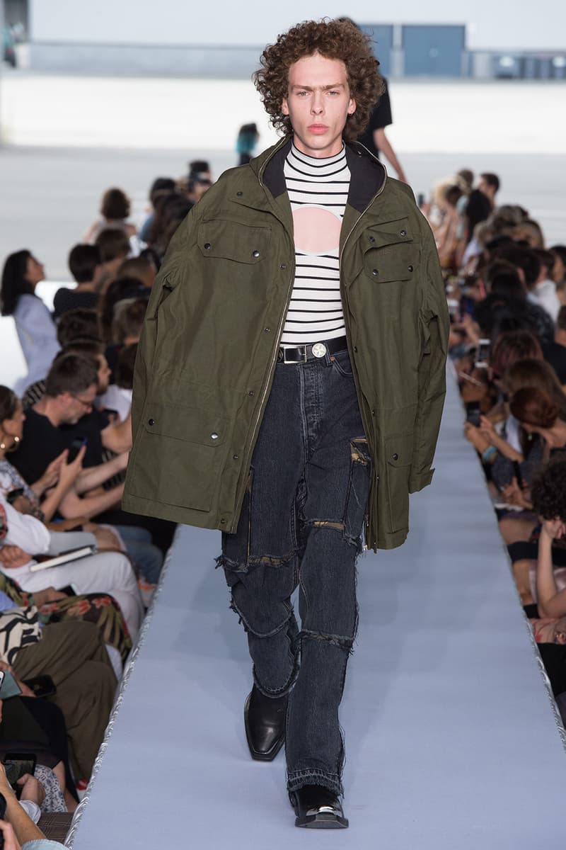 戦争で刻まれた恐怖心と怒りを投影した Vetements 2019年春夏コレクション デムナの母国である現ジョージアとロシア連邦間の紛争をテーマに採用 Demna Gvasalia デムナ・ヴァザリア Vetements ヴェトモン グルジア ジョージア 南オセチア紛争 グラフィックフーディ Tシャツ フィールドジャケット カーゴパンツ トゲを配したハイカットブーツ Reebok リーボック HYPEBEAST ハイプビースト