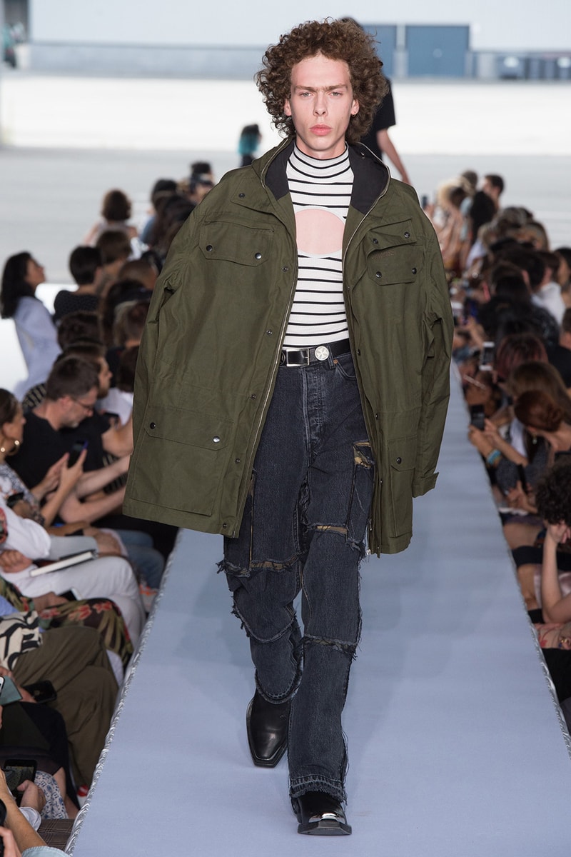 戦争で刻まれた恐怖心と怒りを投影した Vetements 2019年春夏コレクション デムナの母国である現ジョージアとロシア連邦間の紛争をテーマに採用 Demna Gvasalia デムナ・ヴァザリア Vetements ヴェトモン グルジア ジョージア 南オセチア紛争 グラフィックフーディ Tシャツ フィールドジャケット カーゴパンツ トゲを配したハイカットブーツ Reebok リーボック HYPEBEAST ハイプビースト