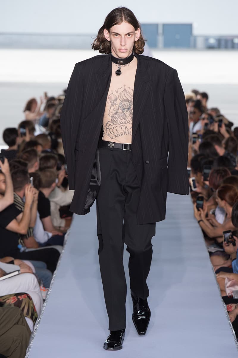 戦争で刻まれた恐怖心と怒りを投影した Vetements 2019年春夏コレクション デムナの母国である現ジョージアとロシア連邦間の紛争をテーマに採用 Demna Gvasalia デムナ・ヴァザリア Vetements ヴェトモン グルジア ジョージア 南オセチア紛争 グラフィックフーディ Tシャツ フィールドジャケット カーゴパンツ トゲを配したハイカットブーツ Reebok リーボック HYPEBEAST ハイプビースト