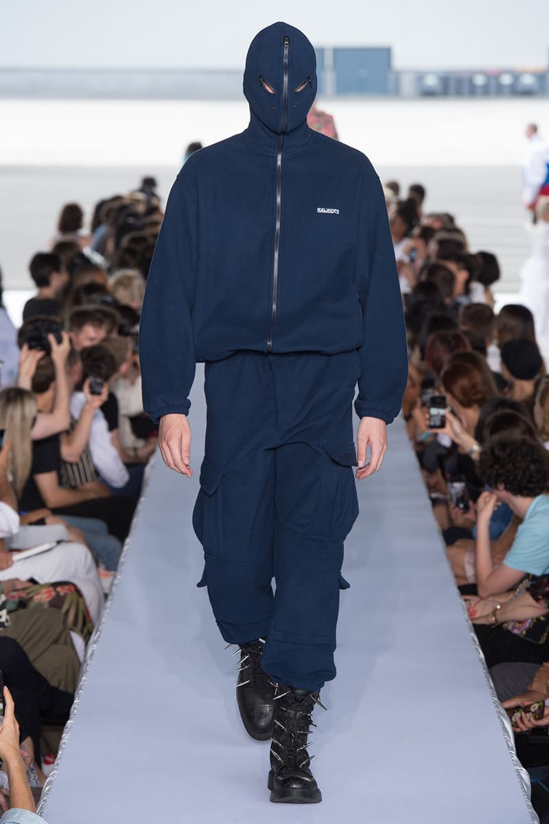 戦争で刻まれた恐怖心と怒りを投影した Vetements 2019年春夏コレクション デムナの母国である現ジョージアとロシア連邦間の紛争をテーマに採用 Demna Gvasalia デムナ・ヴァザリア Vetements ヴェトモン グルジア ジョージア 南オセチア紛争 グラフィックフーディ Tシャツ フィールドジャケット カーゴパンツ トゲを配したハイカットブーツ Reebok リーボック HYPEBEAST ハイプビースト
