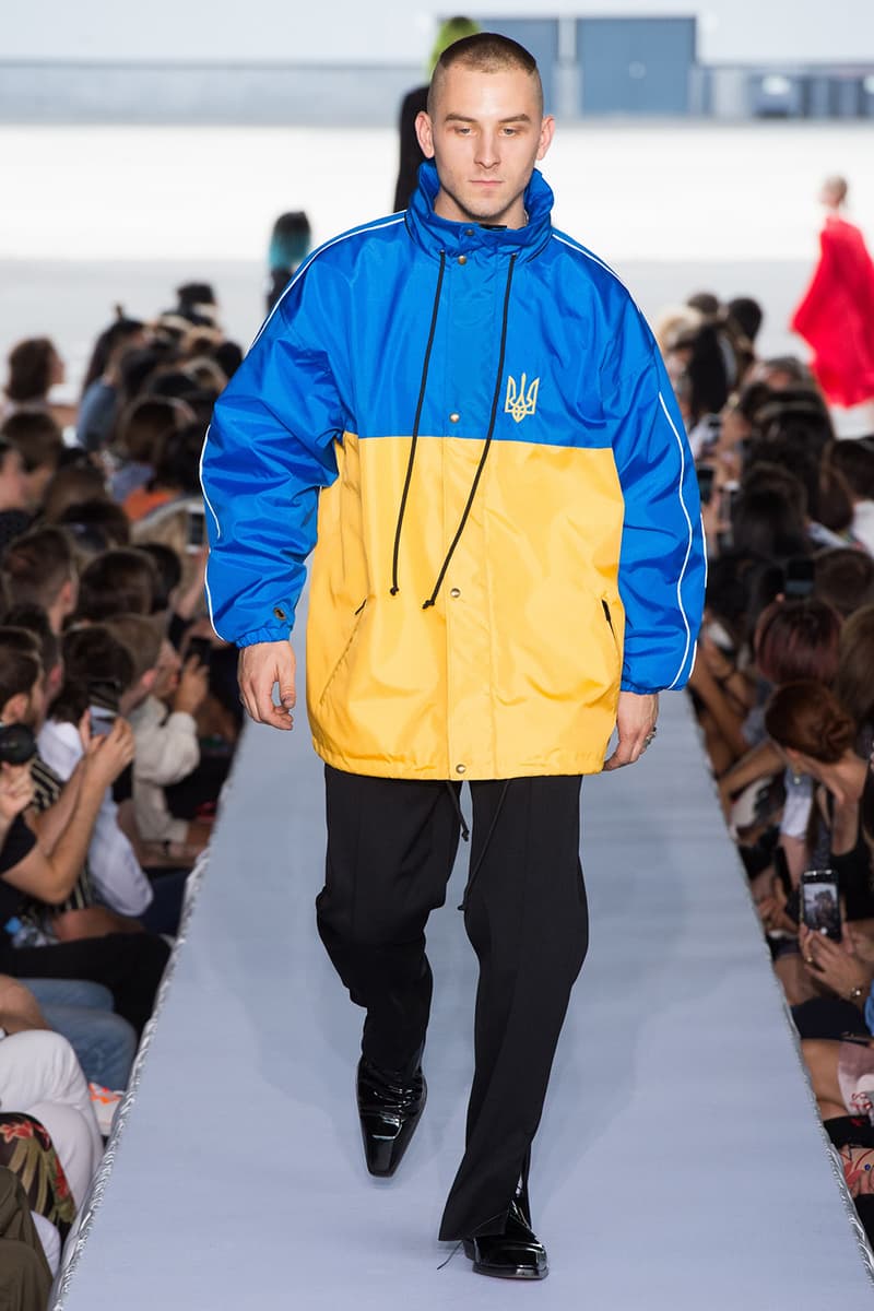 戦争で刻まれた恐怖心と怒りを投影した Vetements 2019年春夏コレクション デムナの母国である現ジョージアとロシア連邦間の紛争をテーマに採用 Demna Gvasalia デムナ・ヴァザリア Vetements ヴェトモン グルジア ジョージア 南オセチア紛争 グラフィックフーディ Tシャツ フィールドジャケット カーゴパンツ トゲを配したハイカットブーツ Reebok リーボック HYPEBEAST ハイプビースト