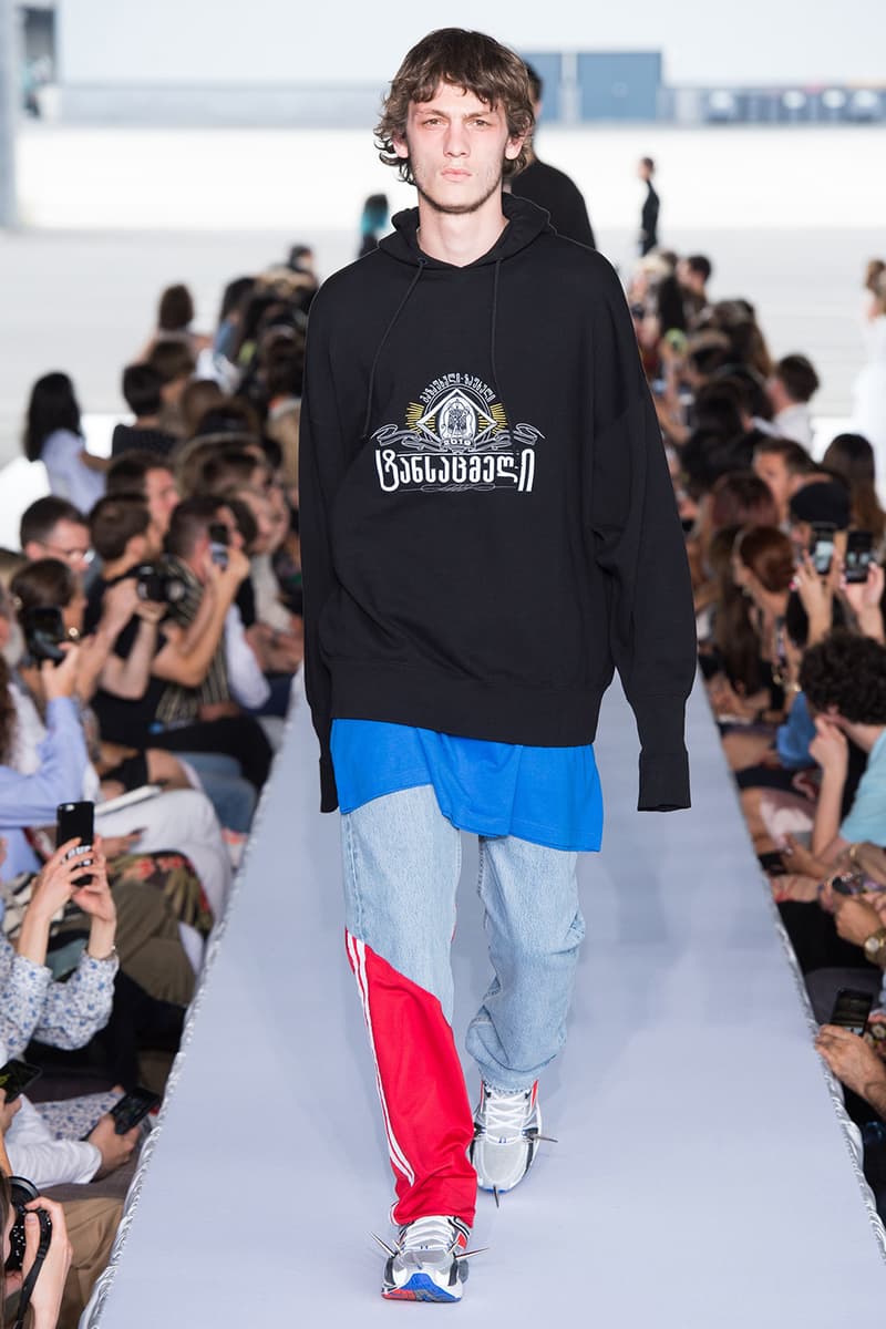 戦争で刻まれた恐怖心と怒りを投影した Vetements 2019年春夏コレクション デムナの母国である現ジョージアとロシア連邦間の紛争をテーマに採用 Demna Gvasalia デムナ・ヴァザリア Vetements ヴェトモン グルジア ジョージア 南オセチア紛争 グラフィックフーディ Tシャツ フィールドジャケット カーゴパンツ トゲを配したハイカットブーツ Reebok リーボック HYPEBEAST ハイプビースト