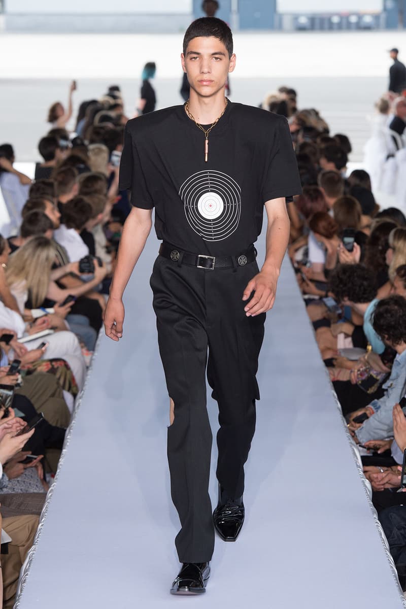 戦争で刻まれた恐怖心と怒りを投影した Vetements 2019年春夏コレクション デムナの母国である現ジョージアとロシア連邦間の紛争をテーマに採用 Demna Gvasalia デムナ・ヴァザリア Vetements ヴェトモン グルジア ジョージア 南オセチア紛争 グラフィックフーディ Tシャツ フィールドジャケット カーゴパンツ トゲを配したハイカットブーツ Reebok リーボック HYPEBEAST ハイプビースト