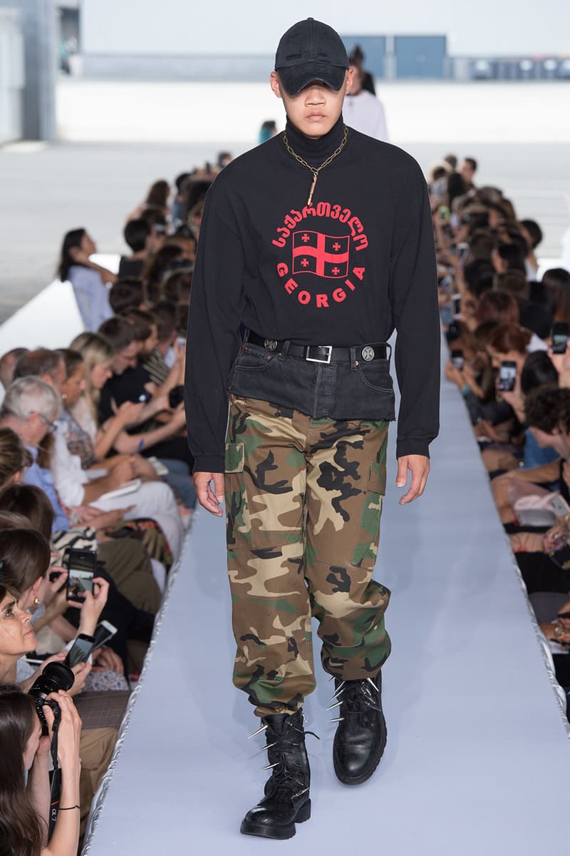 戦争で刻まれた恐怖心と怒りを投影した Vetements 2019年春夏コレクション デムナの母国である現ジョージアとロシア連邦間の紛争をテーマに採用 Demna Gvasalia デムナ・ヴァザリア Vetements ヴェトモン グルジア ジョージア 南オセチア紛争 グラフィックフーディ Tシャツ フィールドジャケット カーゴパンツ トゲを配したハイカットブーツ Reebok リーボック HYPEBEAST ハイプビースト