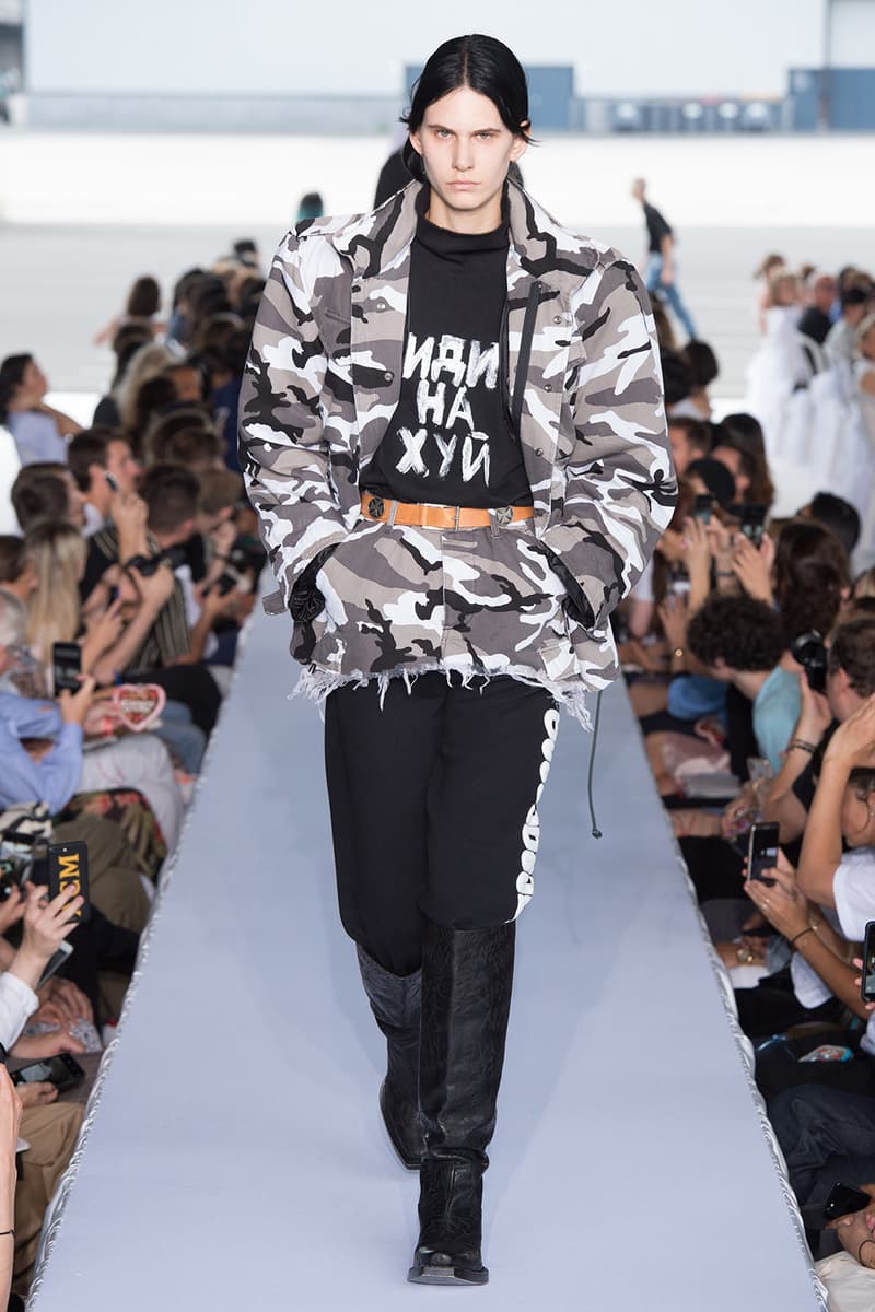 戦争で刻まれた恐怖心と怒りを投影した Vetements 2019年春夏コレクション デムナの母国である現ジョージアとロシア連邦間の紛争をテーマに採用 Demna Gvasalia デムナ・ヴァザリア Vetements ヴェトモン グルジア ジョージア 南オセチア紛争 グラフィックフーディ Tシャツ フィールドジャケット カーゴパンツ トゲを配したハイカットブーツ Reebok リーボック HYPEBEAST ハイプビースト