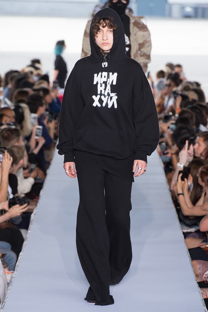 戦争で刻まれた恐怖心と怒りを投影した Vetements 2019年春夏コレクション デムナの母国である現ジョージアとロシア連邦間の紛争をテーマに採用 Demna Gvasalia デムナ・ヴァザリア Vetements ヴェトモン グルジア ジョージア 南オセチア紛争 グラフィックフーディ Tシャツ フィールドジャケット カーゴパンツ トゲを配したハイカットブーツ Reebok リーボック HYPEBEAST ハイプビースト